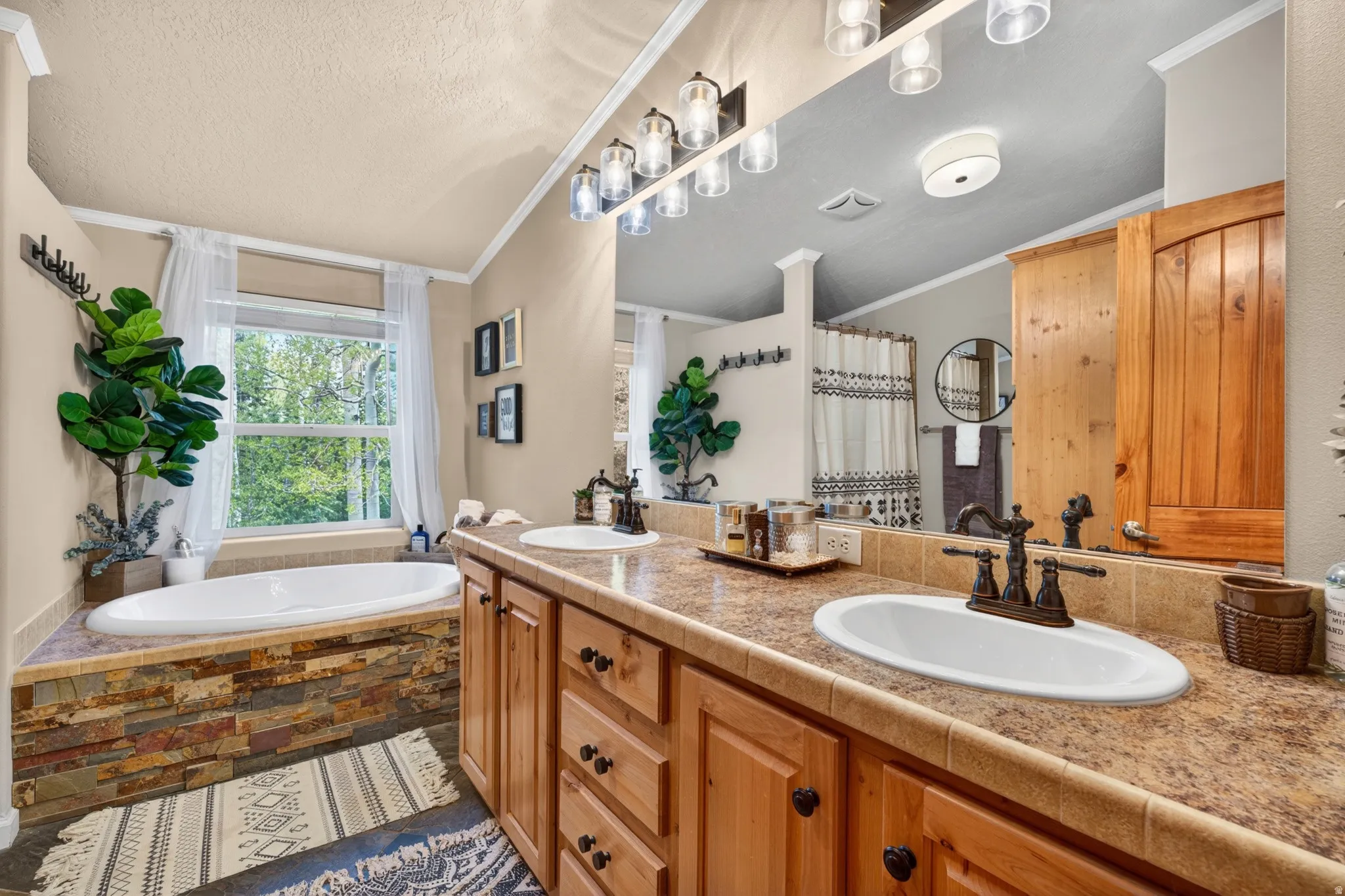 Bathroom featuring a double vanity with wood cabinetry and an oval drop-in sink