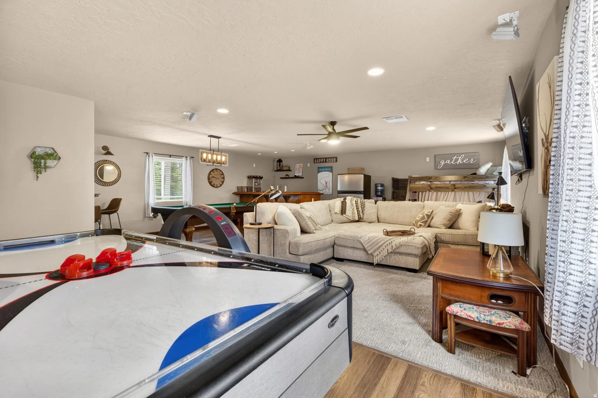 Spacious room featuring wood-finish flooring, recessed lighting, and a ceiling fan