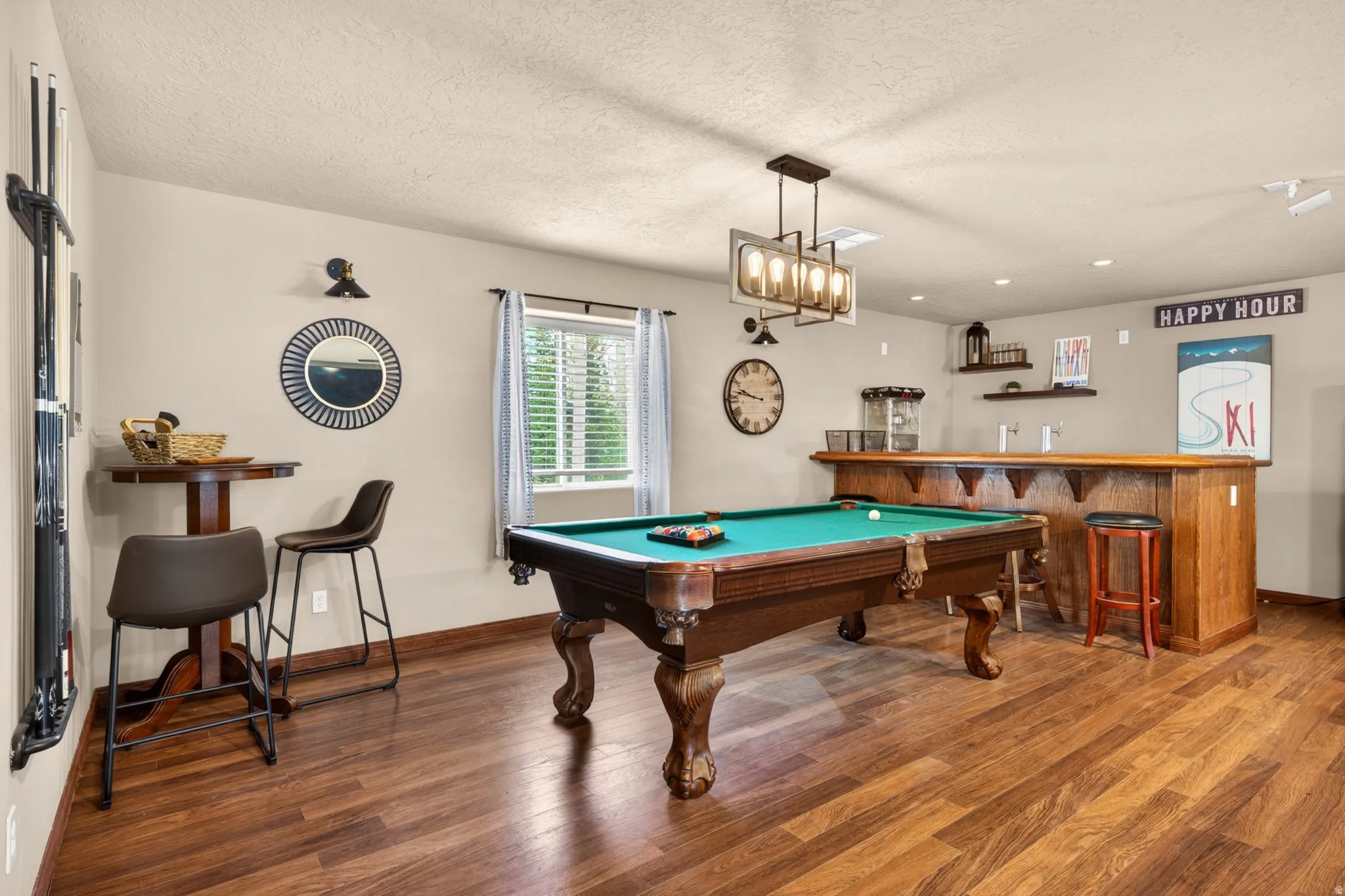 Recreation room featuring a classic billiards table, wood-finish flooring, and a built-in wet bar with a wood countertop