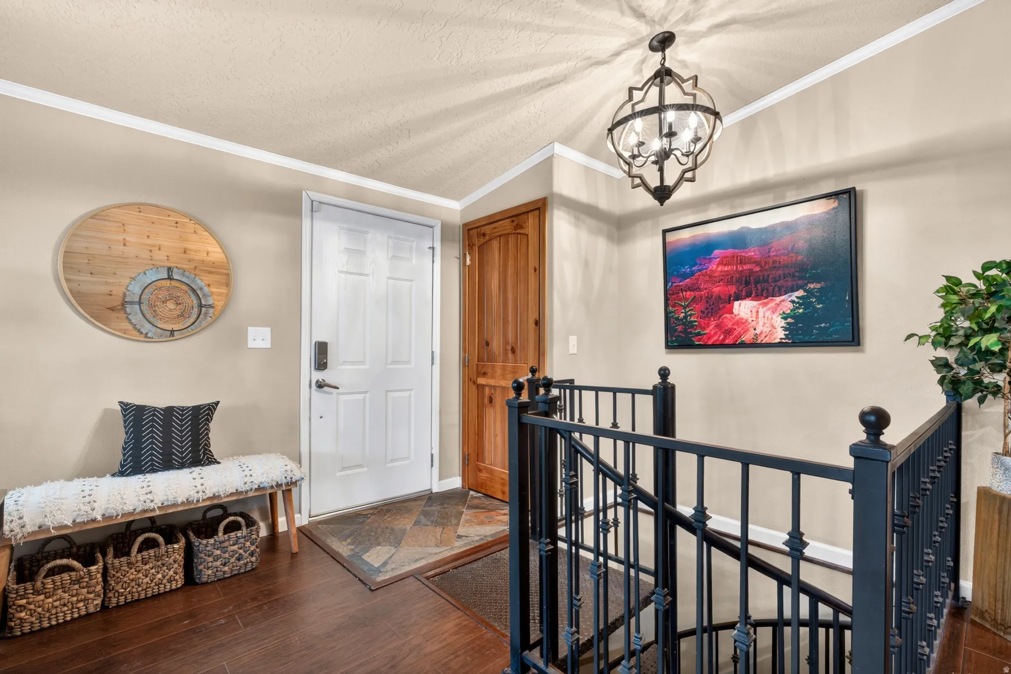 Entry foyer featuring dark wood-finish flooring, a decorative wrought iron chandelier, and a white paneled entry door