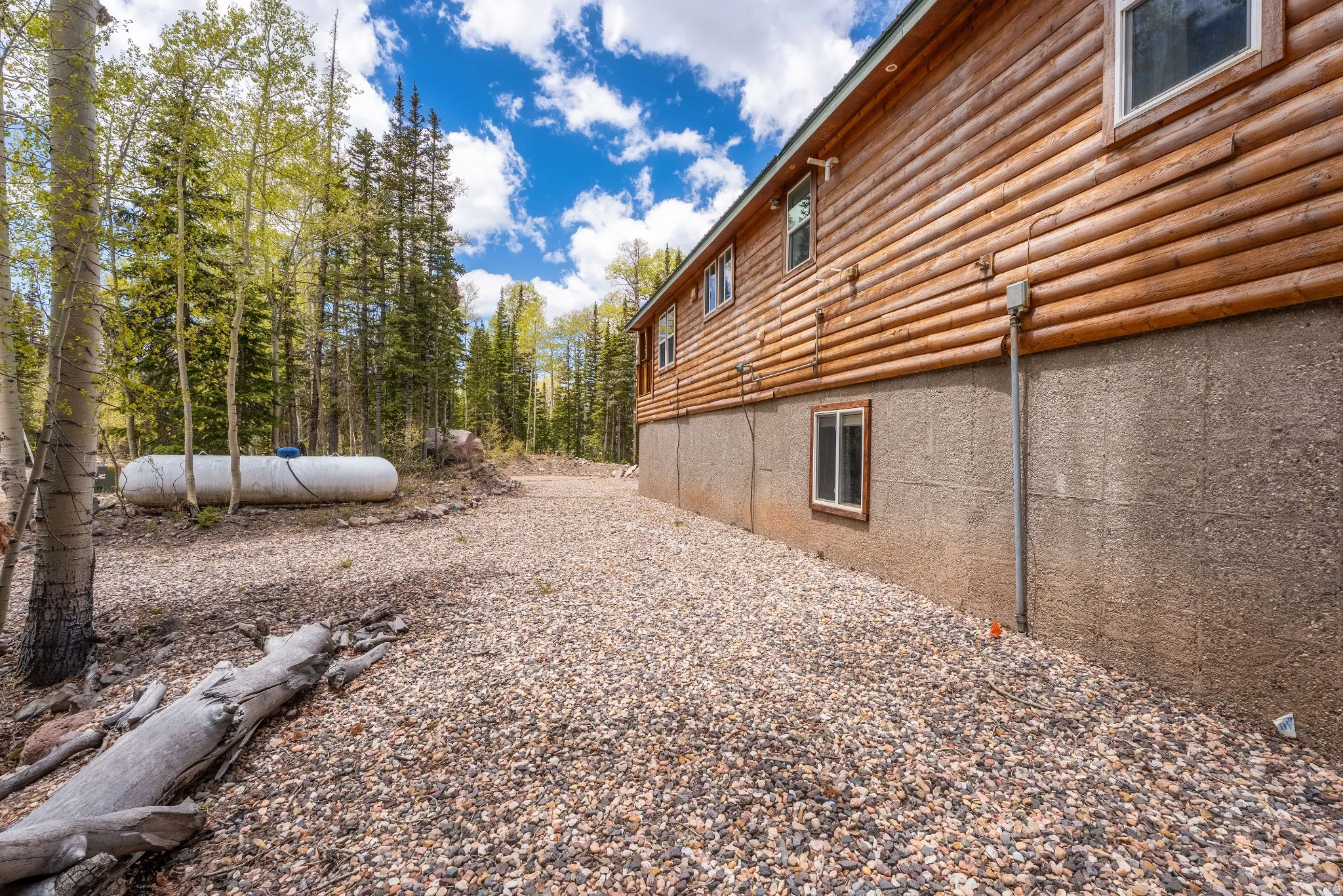Wood-sided exterior with a gravel perimeter and a concrete foundation
