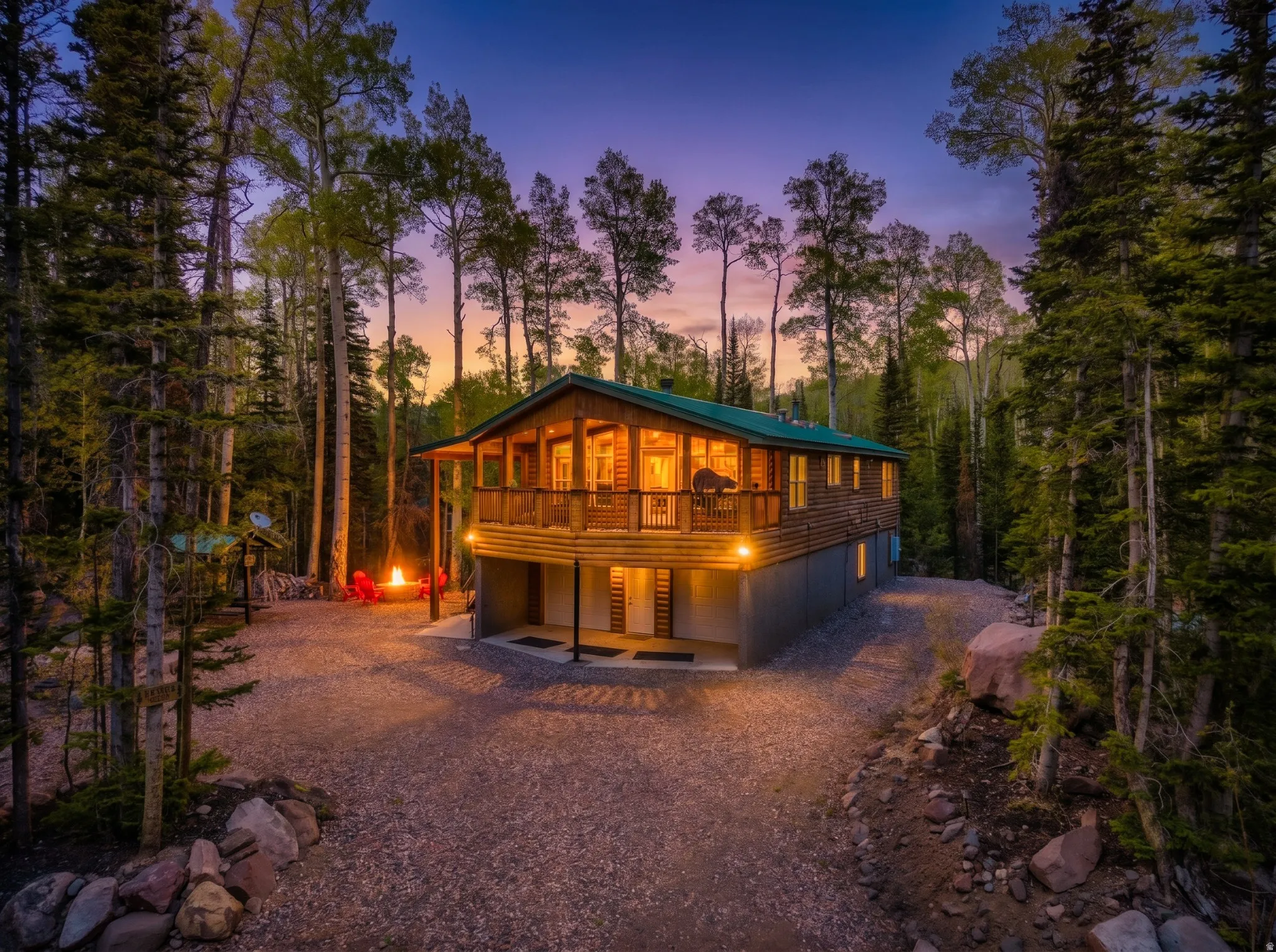 Rustic wood-sided cabin surrounded by mature evergreen and deciduous trees