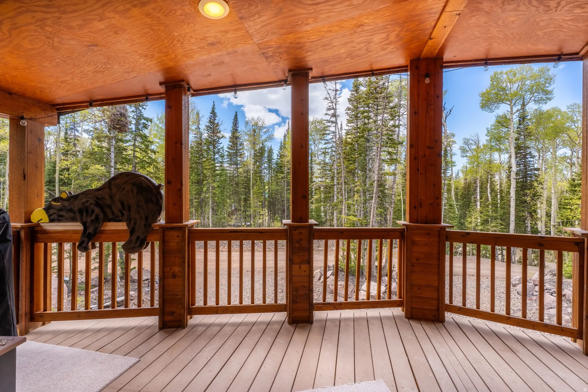 Covered outdoor deck with light wood-finish flooring