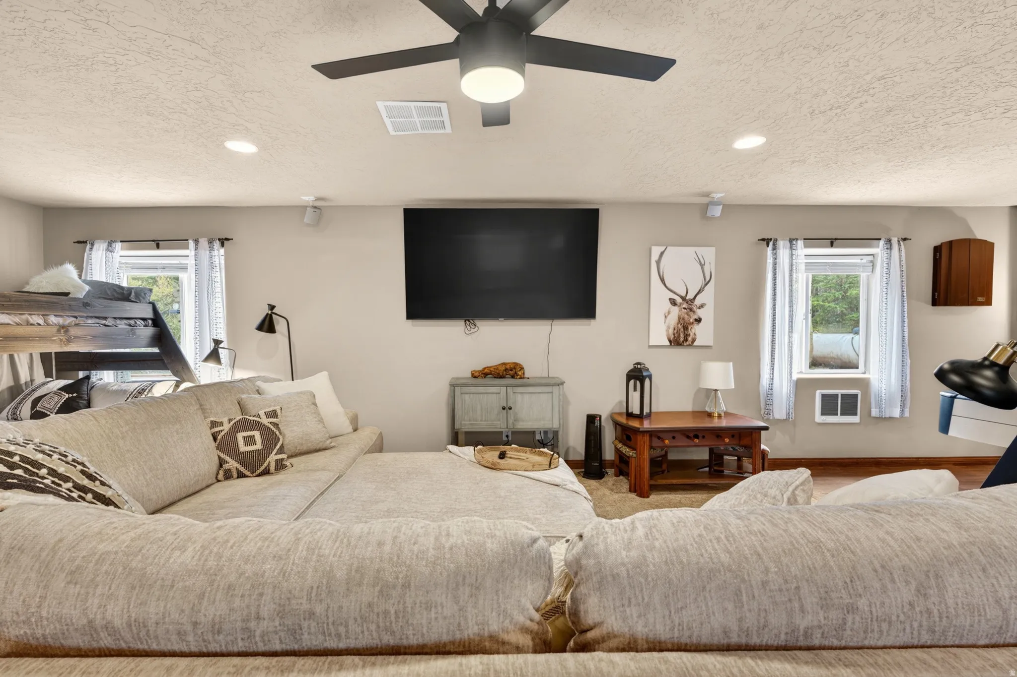 Spacious room featuring light-colored walls, recessed lighting, and a ceiling fan with integrated lighting
