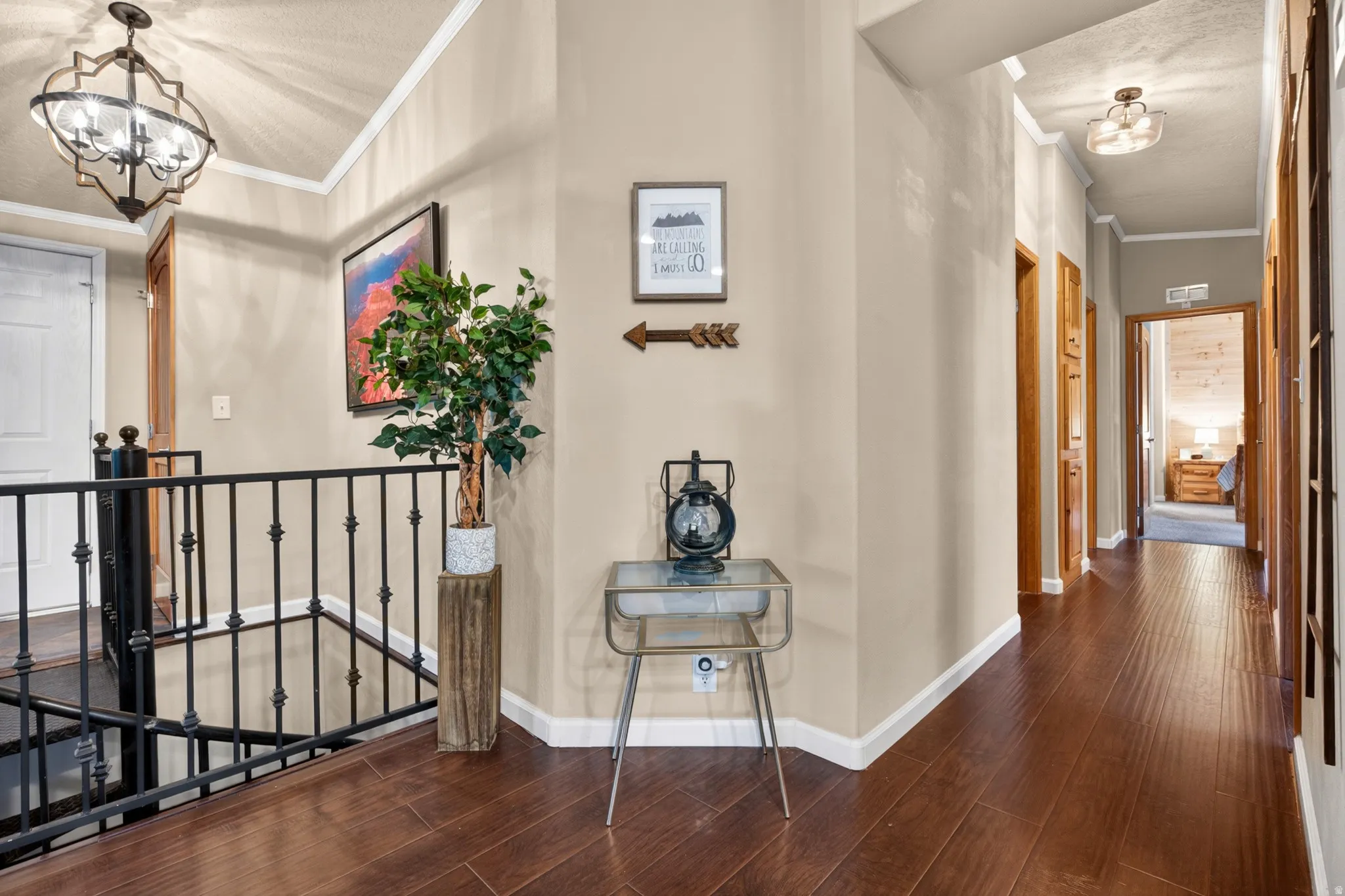 Hallway featuring wood-finish flooring, neutral wall paint, and white trim