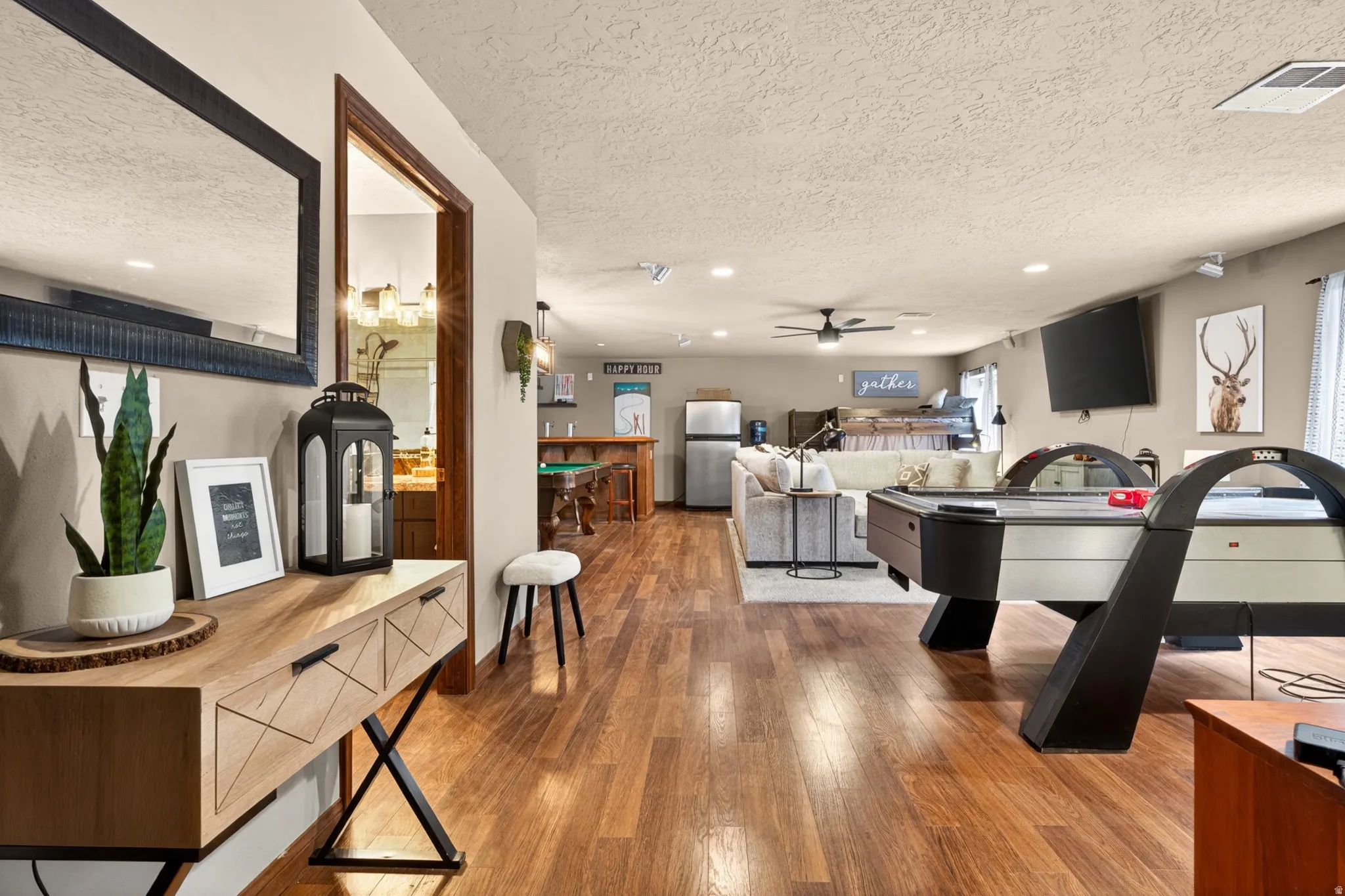 Open-concept recreation area featuring wood-finish flooring, a built-in wet bar, recessed lighting, and a ceiling fan