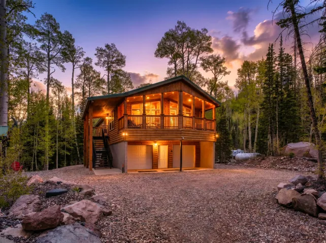 Wood-sided cabin featuring a raised balcony with wood railings and recessed lighting