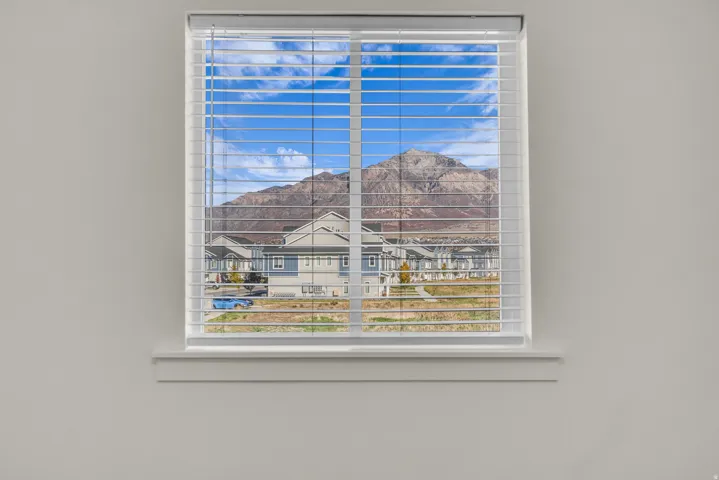White-framed window featuring horizontal blinds