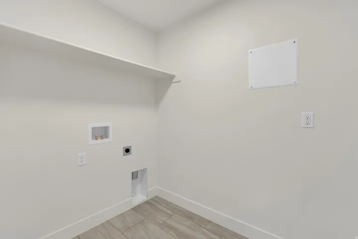 Utility room featuring a built-in shelf, appliance hookups, and wood-finish flooring