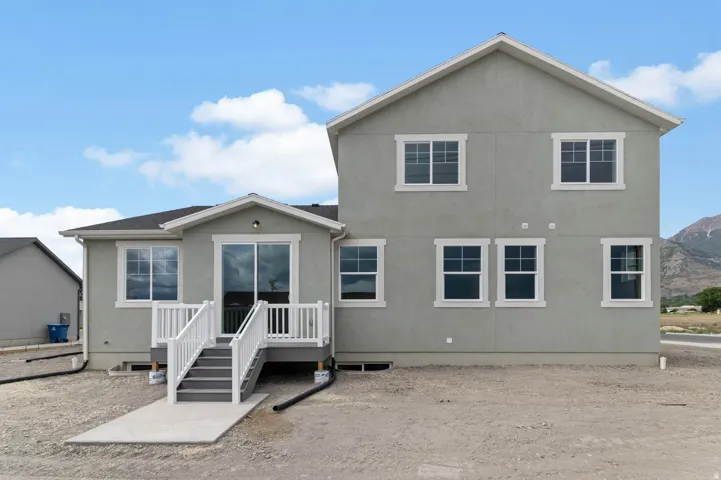 Rear exterior featuring a two-story design with stucco siding and white trim