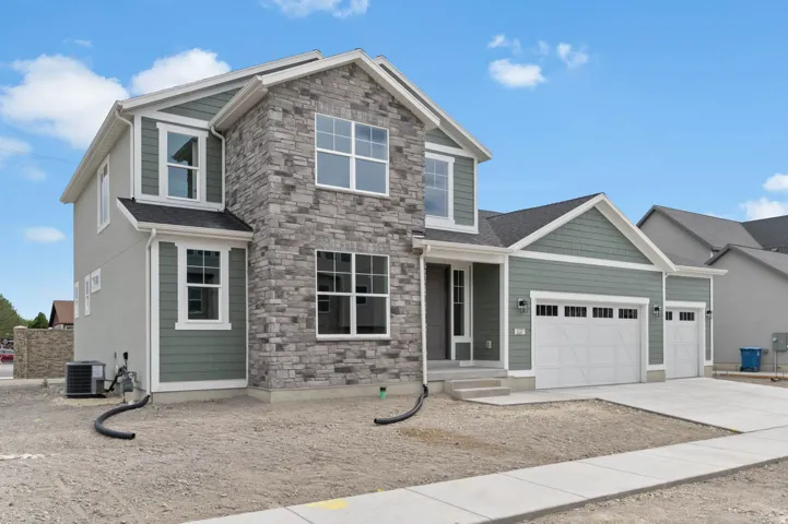 Contemporary two-story residence featuring a stone and siding exterior, multiple gables, and a prominent entryway