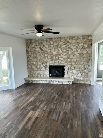 Living area featuring a floor-to-ceiling stone fireplace with an integrated firebox and hearth