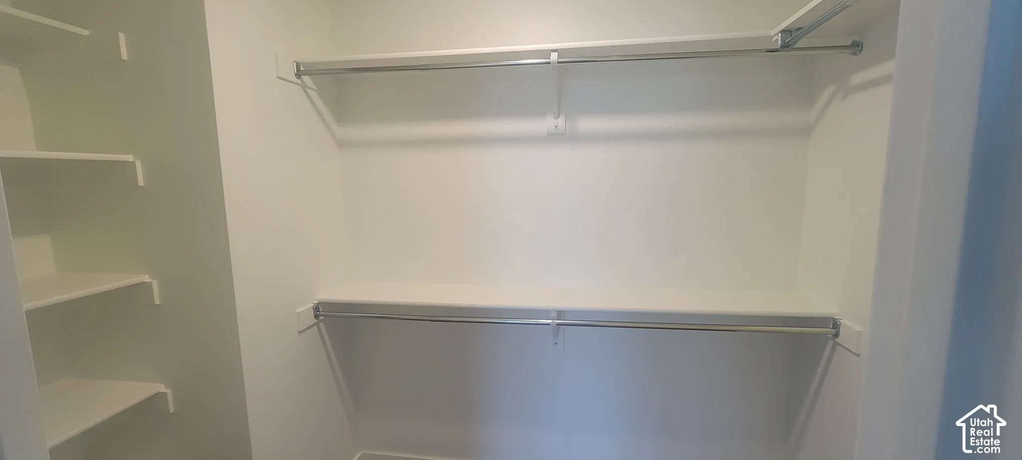 Master bedroom Spacious walk-in closet featuring built-in shelving and dual hanging rods