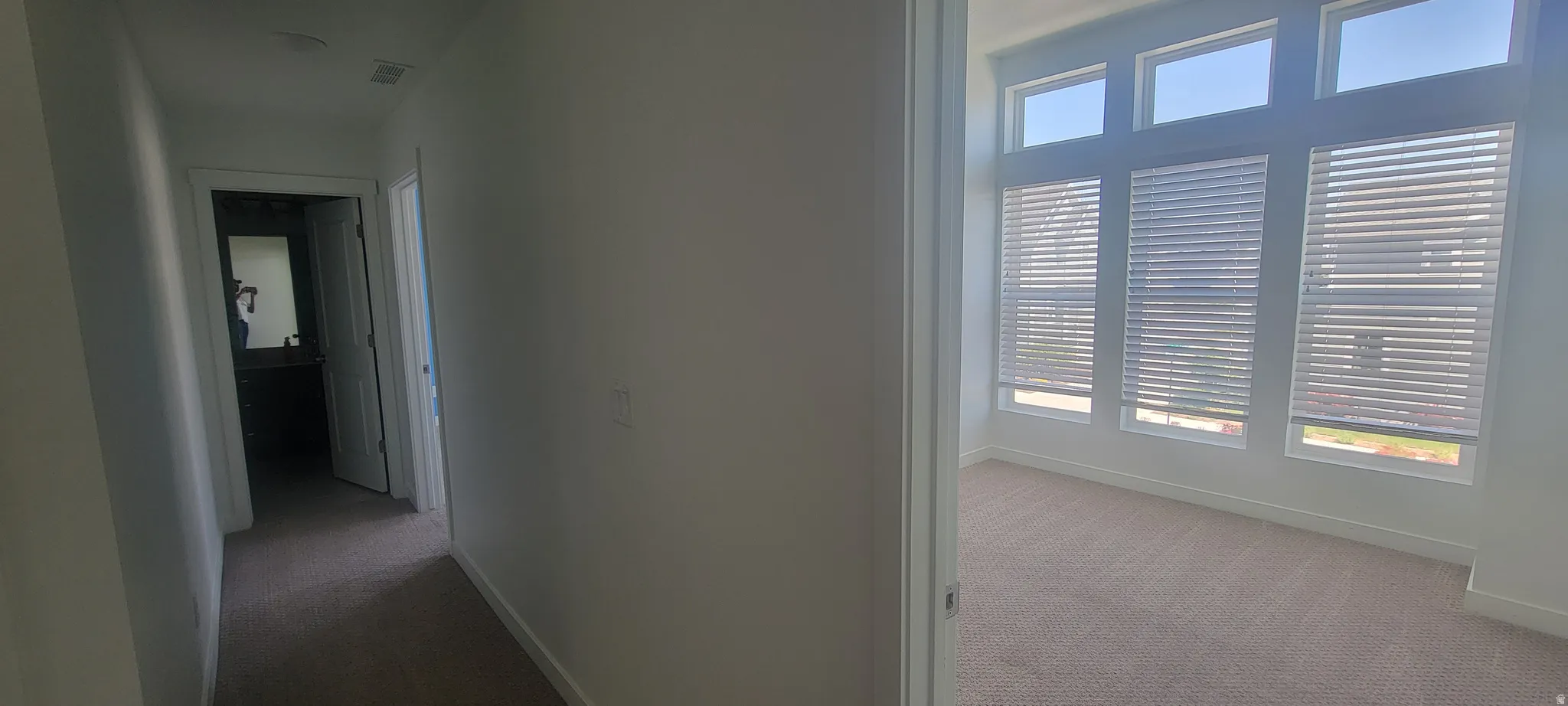 Bright interior room featuring a series of tall windows with horizontal blinds