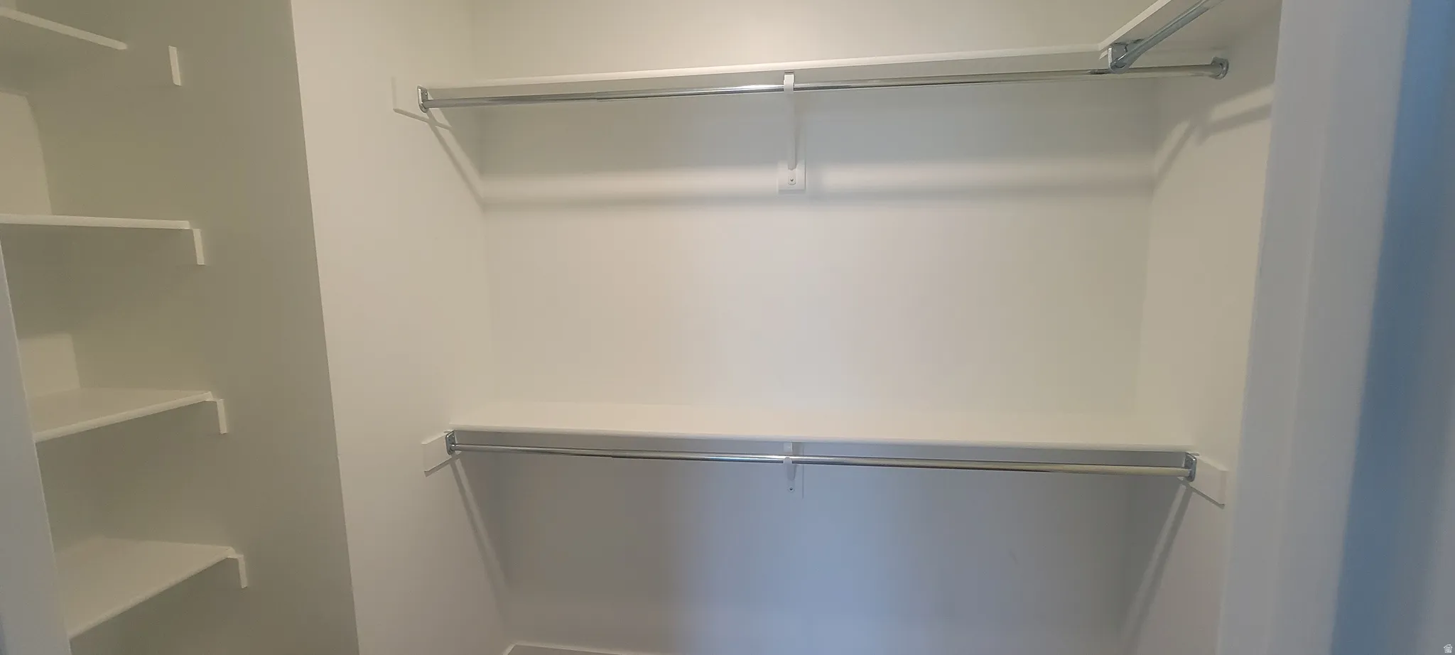 Master bedroom Spacious walk-in closet featuring built-in shelving and dual hanging rods