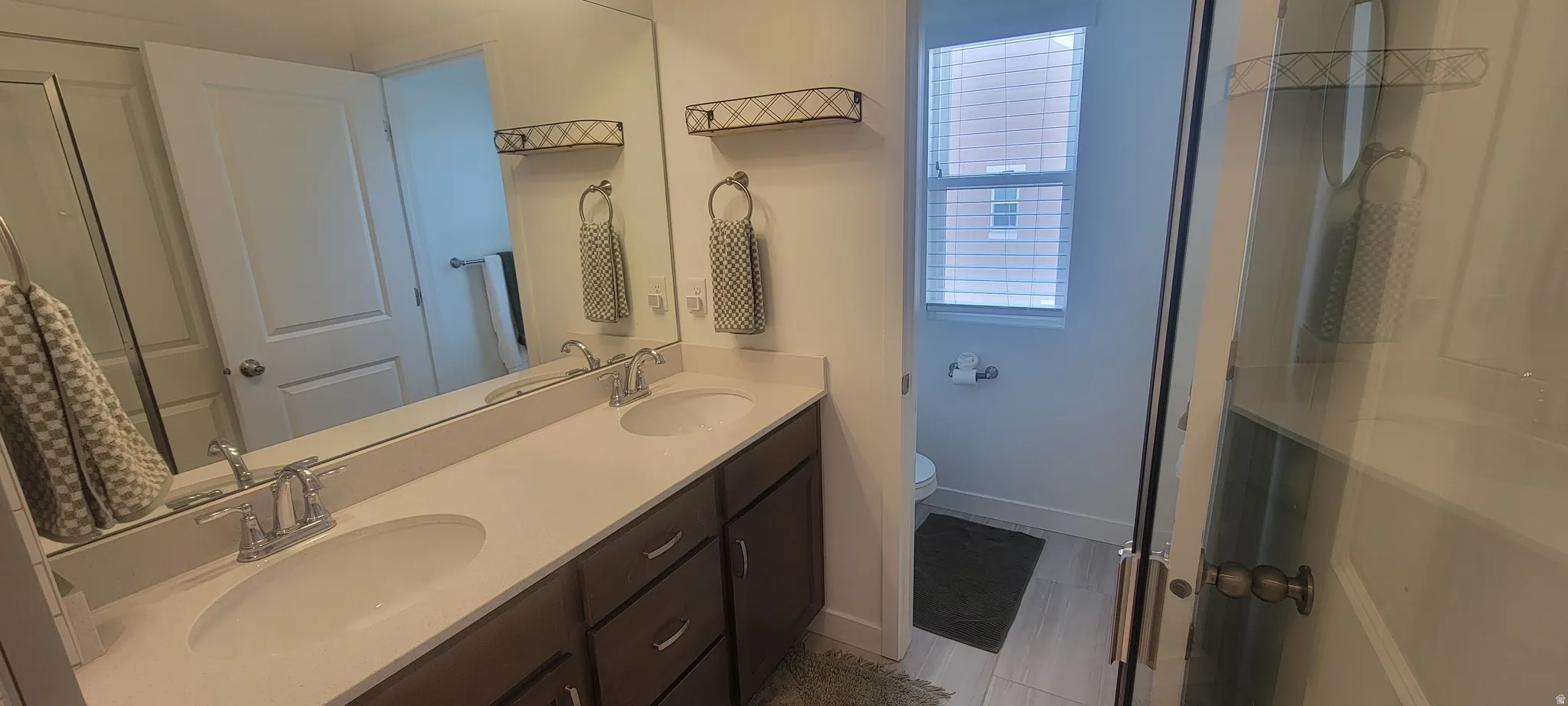 master Bathroom featuring a double vanity with undermount sinks, chrome fixtures, and a large wall-mounted mirror