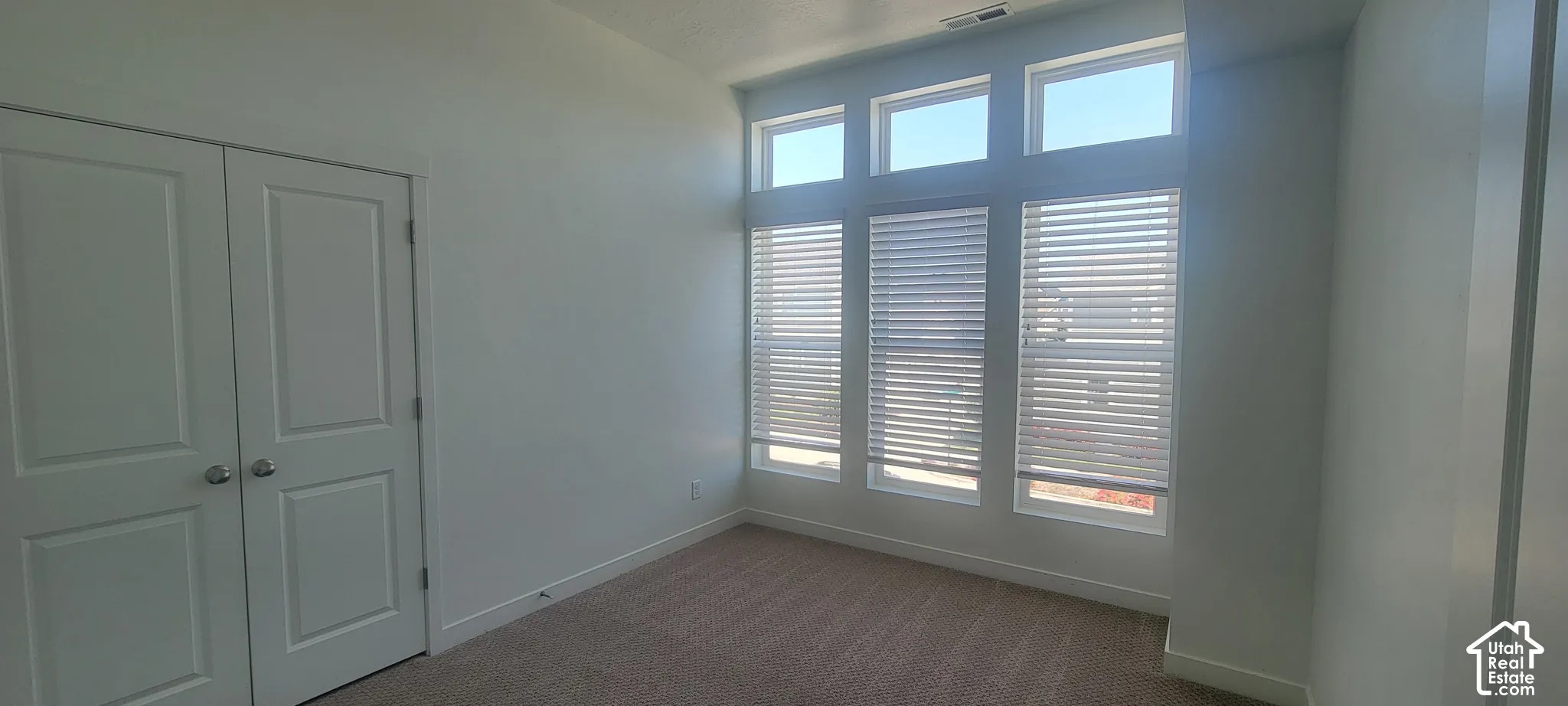 Room featuring a multi-pane window system with integrated blinds, providing ample ambient light