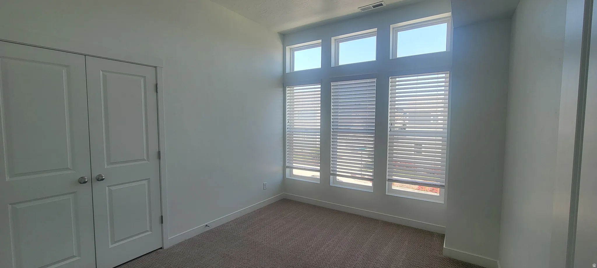 Room featuring a multi-pane window system with integrated blinds, providing ample ambient light