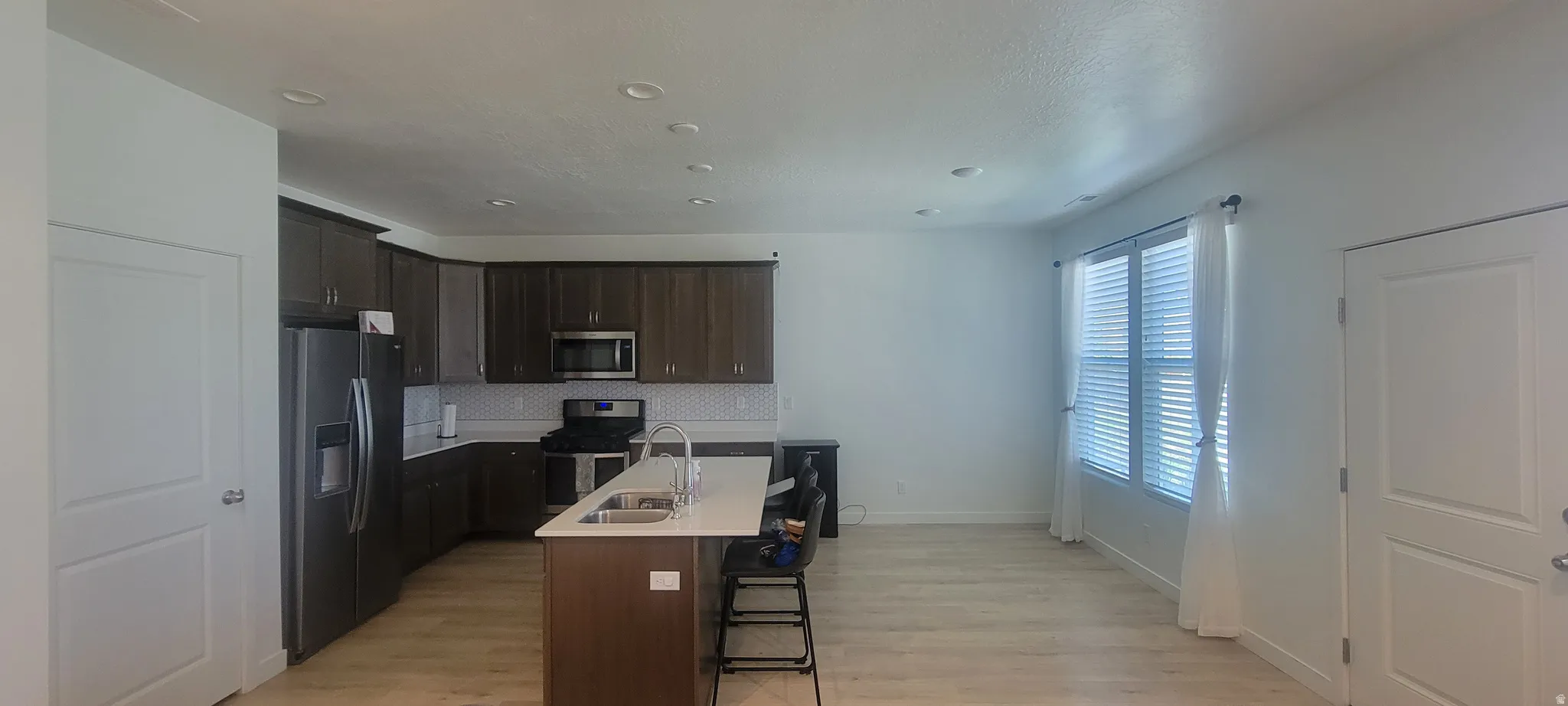 Open-concept kitchen and living area featuring wood-finish flooring