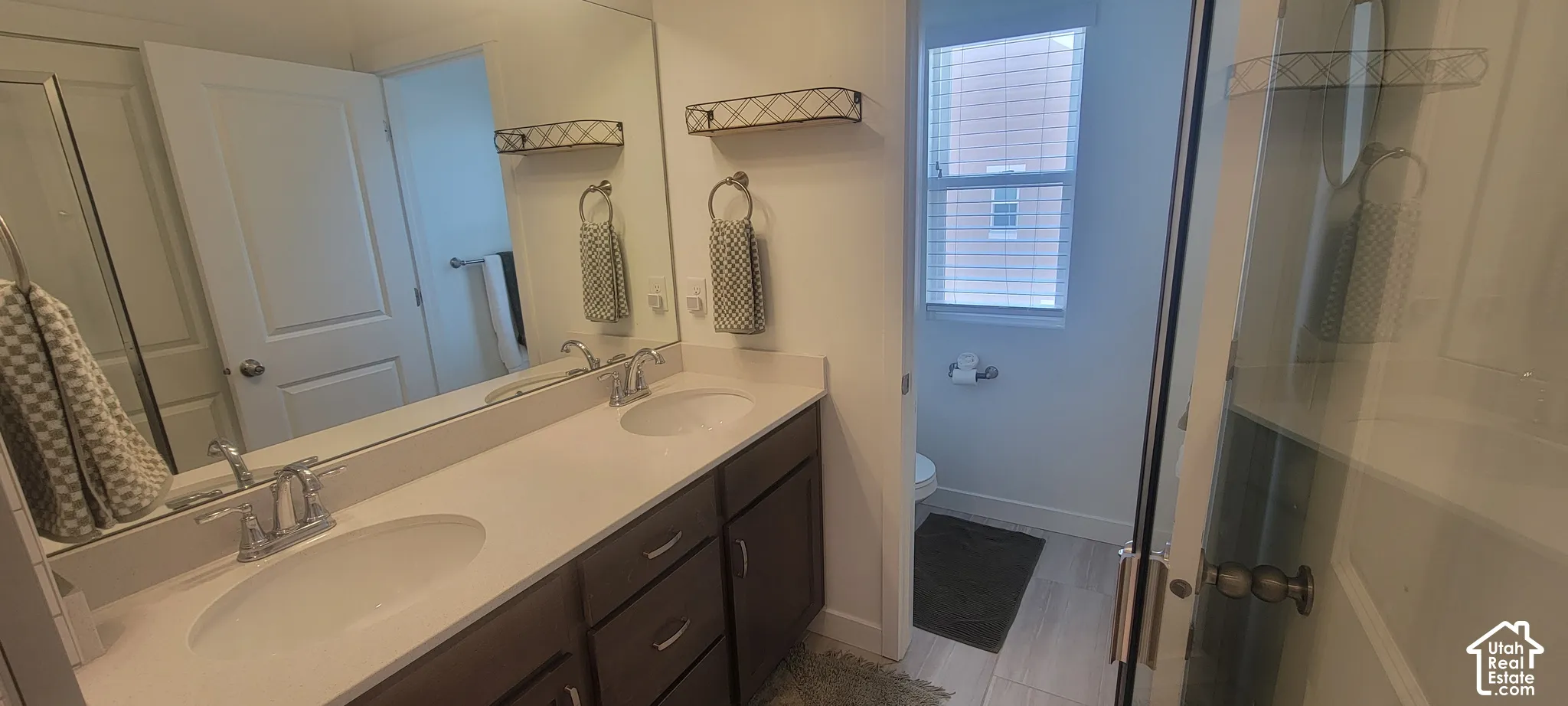 master Bathroom featuring a double vanity with undermount sinks, chrome fixtures, and a large wall-mounted mirror