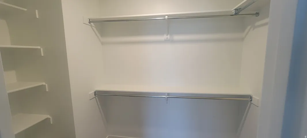 Master bedroom Spacious walk-in closet featuring built-in shelving and dual hanging rods