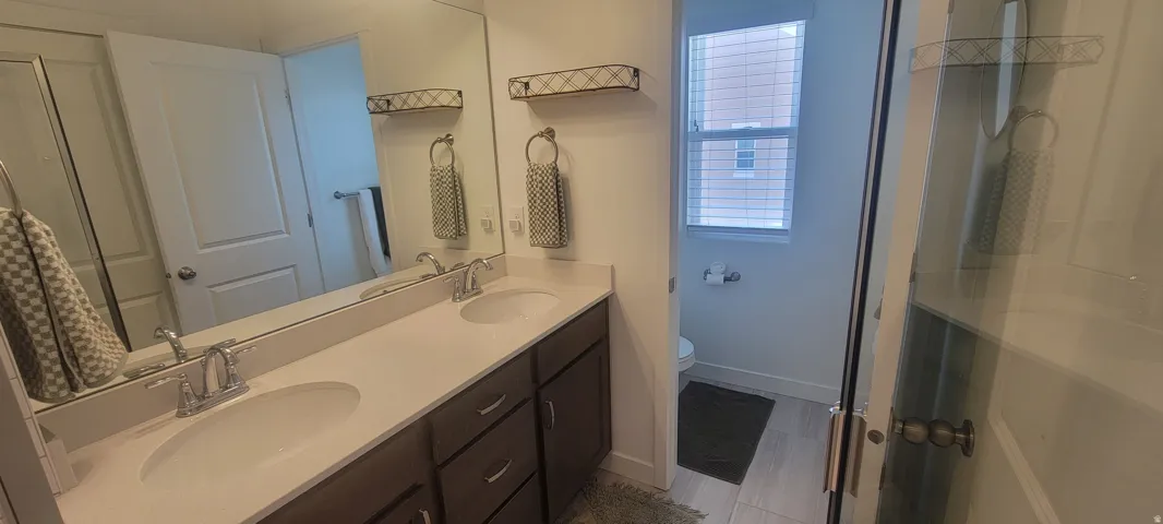master Bathroom featuring a double vanity with undermount sinks, chrome fixtures, and a large wall-mounted mirror