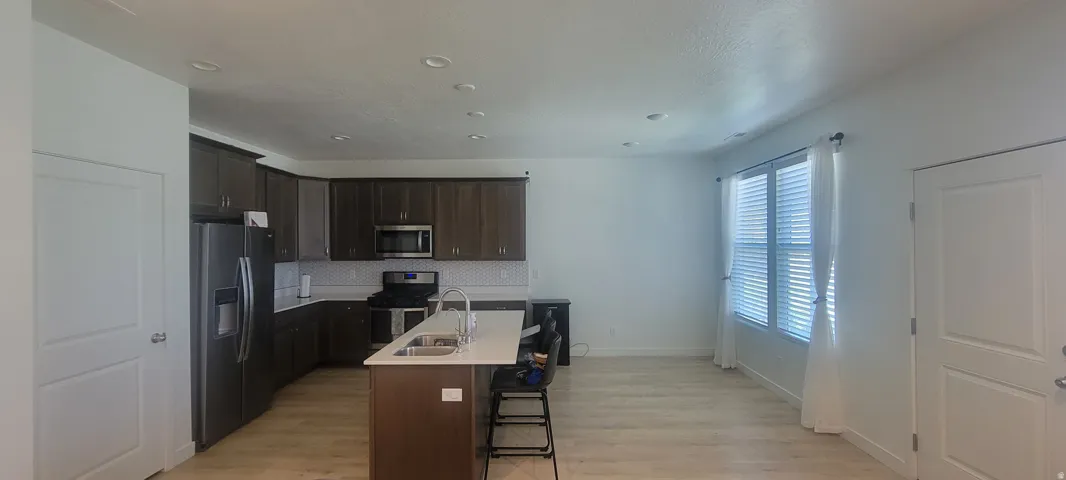 Open-concept kitchen and living area featuring wood-finish flooring