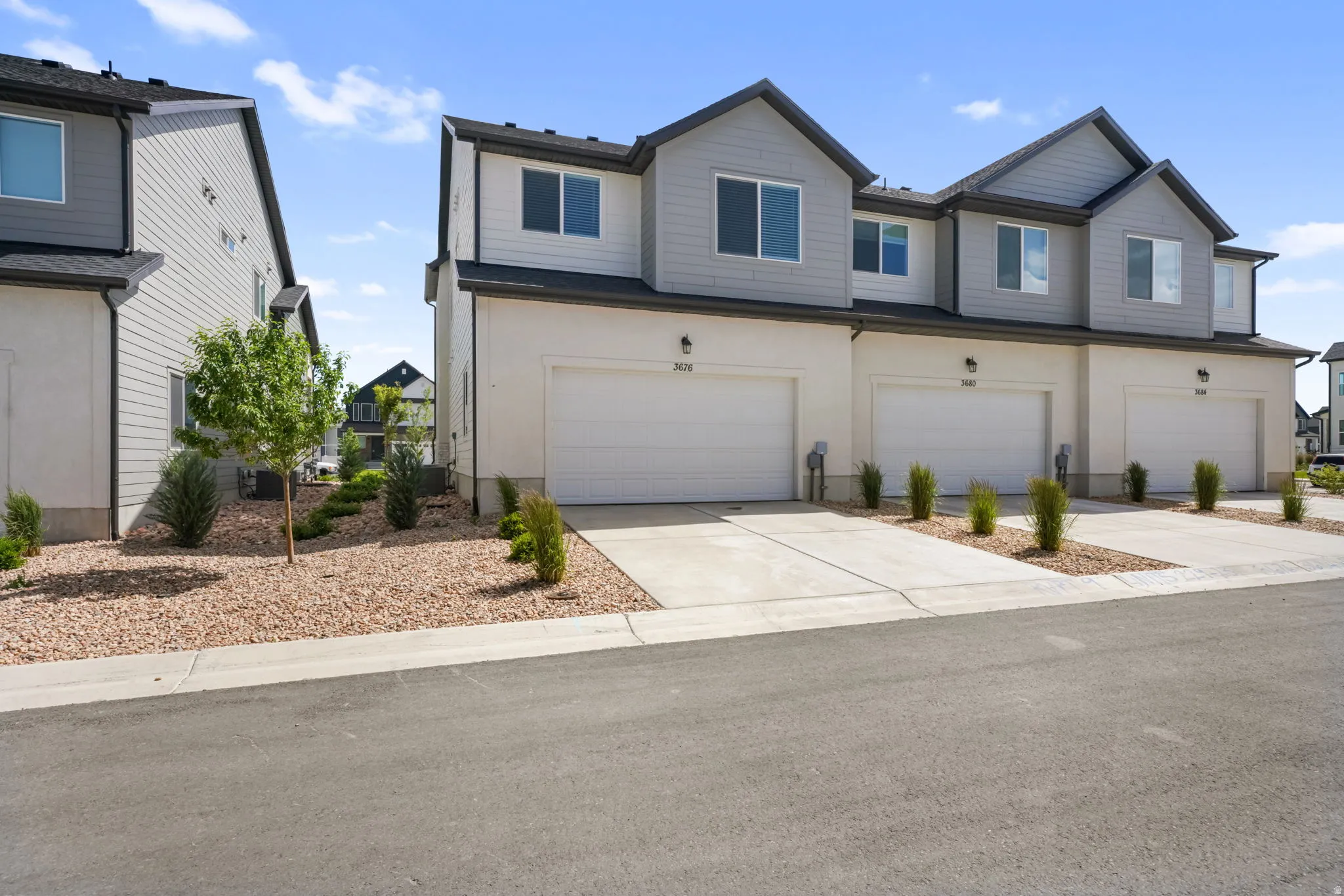 Contemporary townhome exterior featuring light-colored siding and dark trim