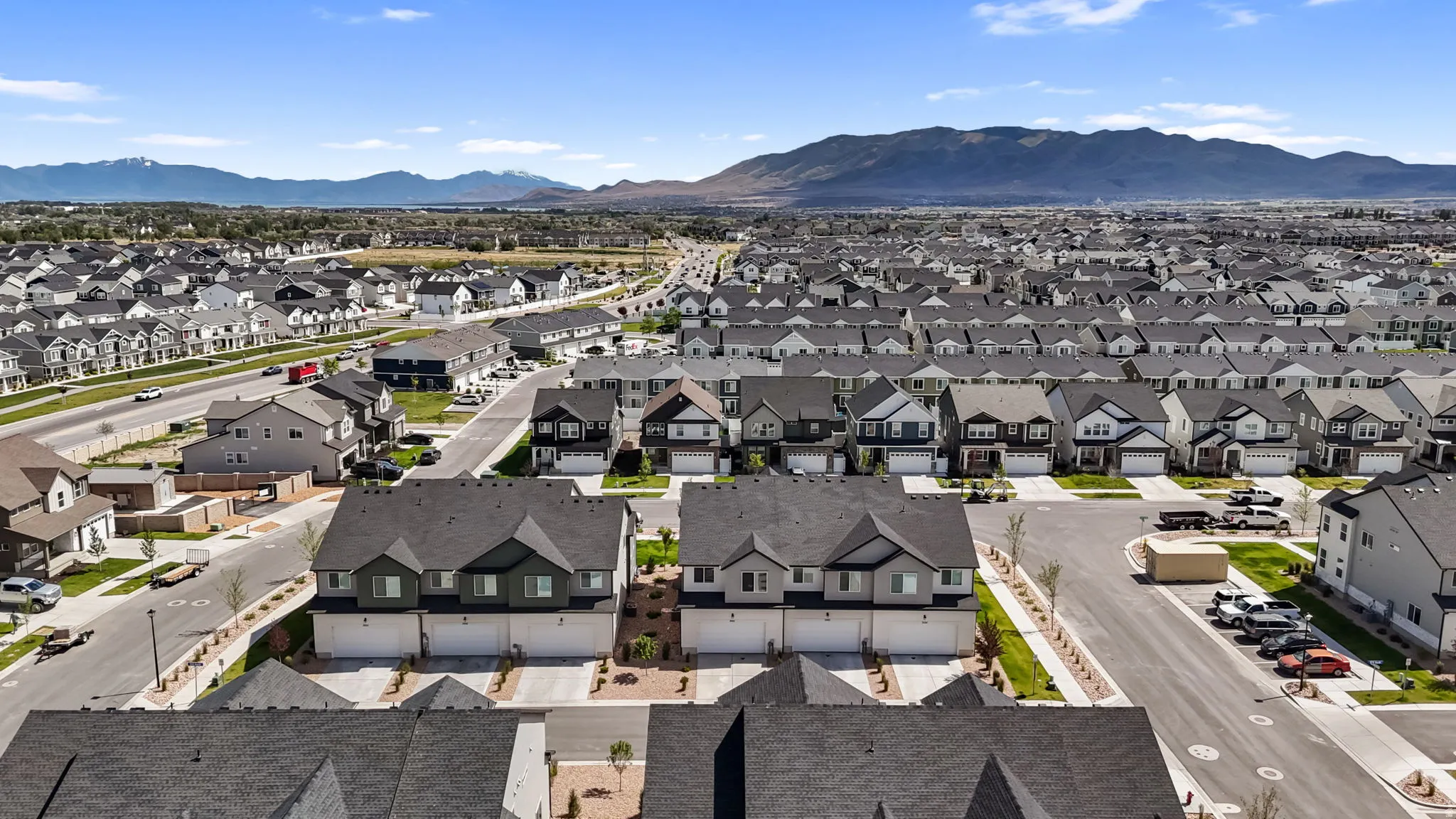 Expansive residential area featuring numerous single-family homes and townhomes, characterized by varied architectural styles and dark-toned roofing