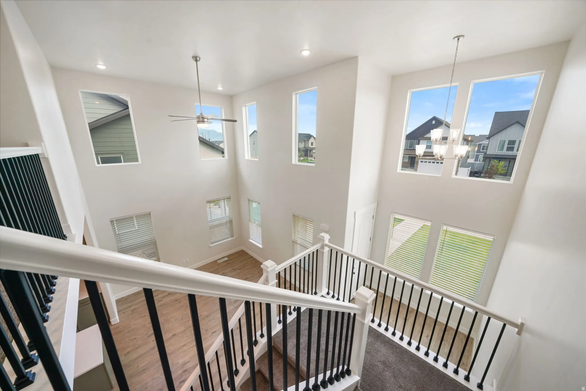 Two-story foyer with a chandelier and a ceiling fan