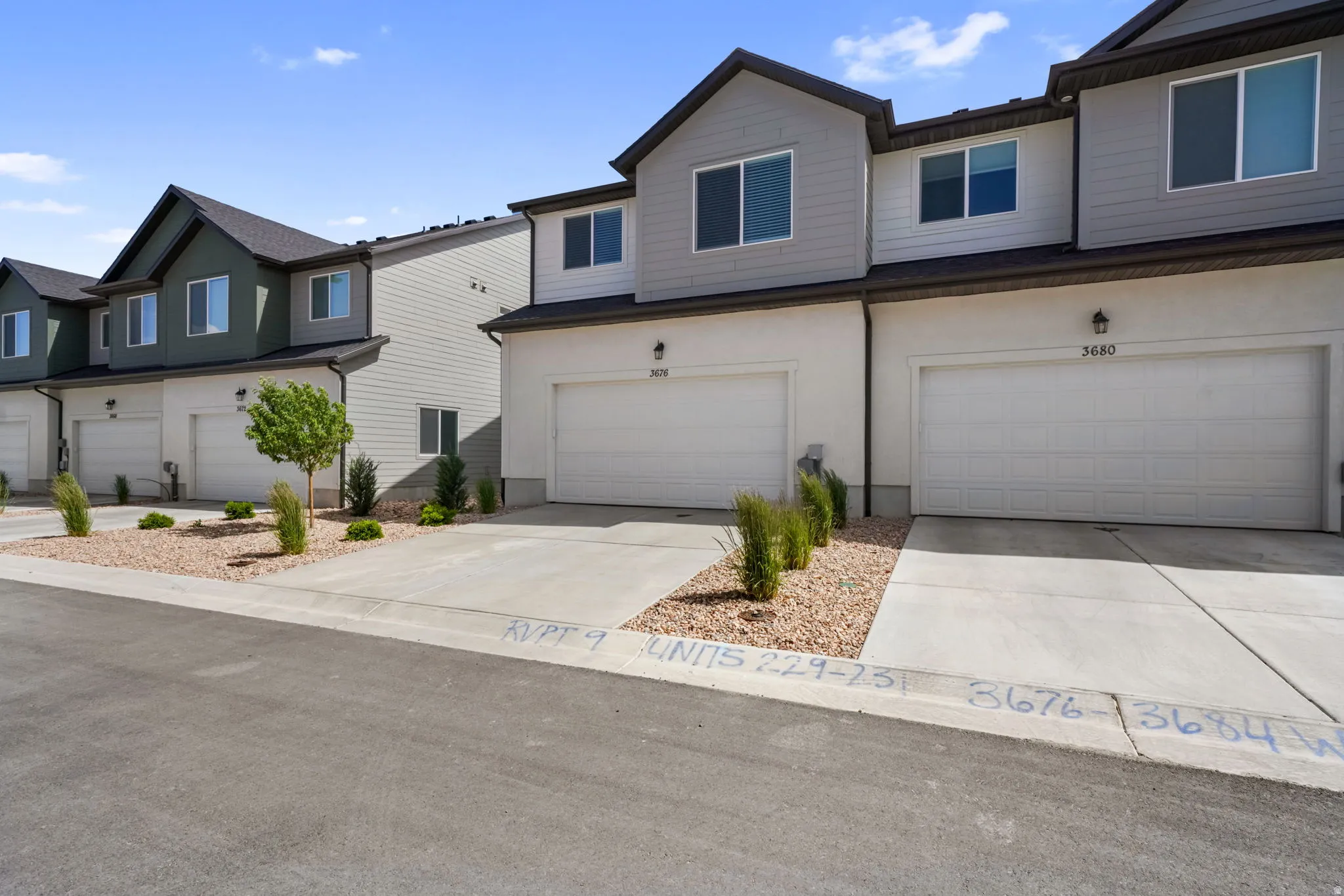 Contemporary townhome exteriors featuring varied siding materials and individual garage access