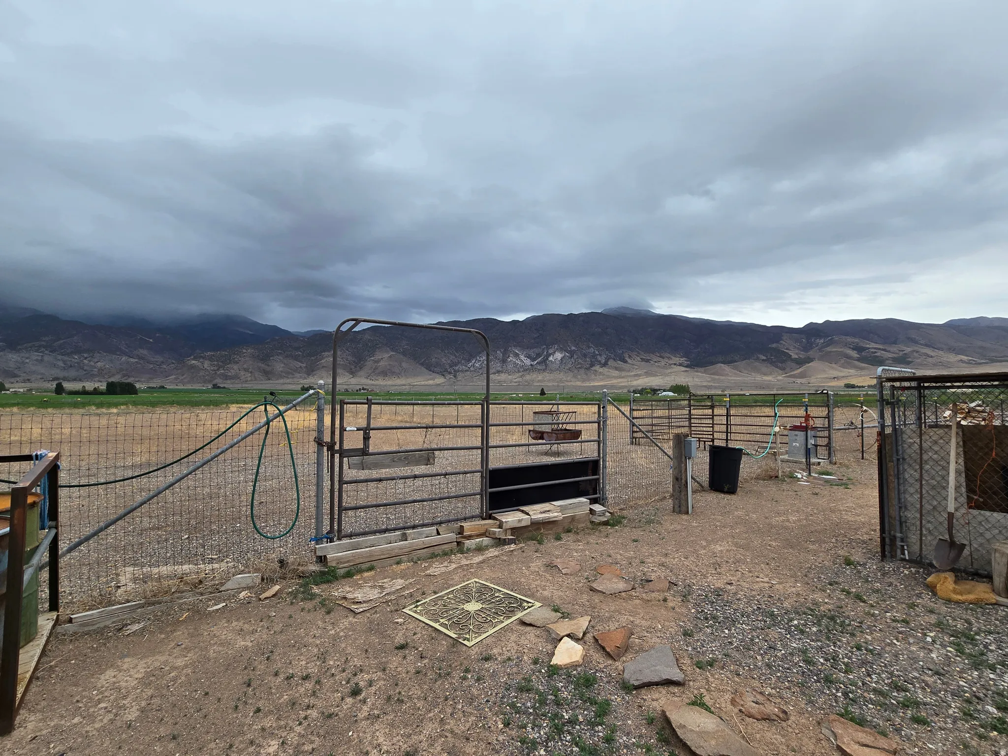 Expansive outdoor area featuring a metal fence, gate, and gravel ground cover