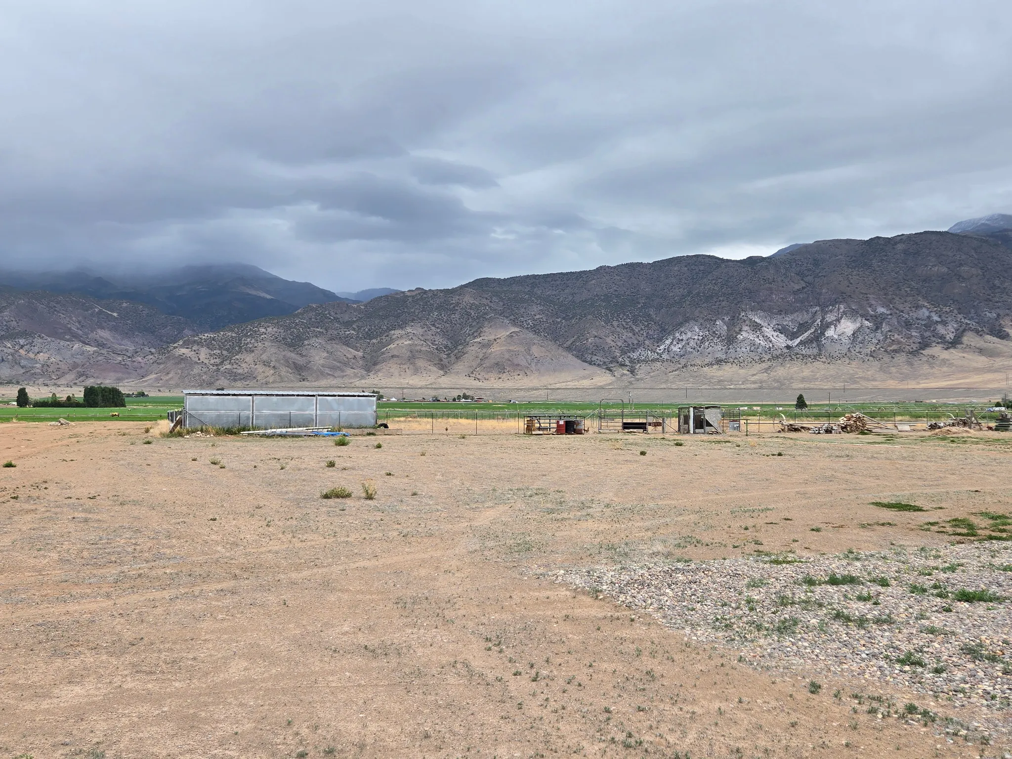 Expansive open lot featuring a large outbuilding with a corrugated metal roof
