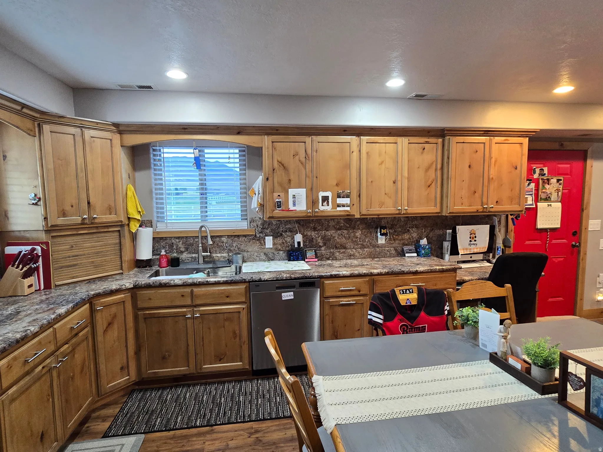 Kitchen featuring wood cabinetry, speckled countertops, stainless steel sink, and recessed lighting
