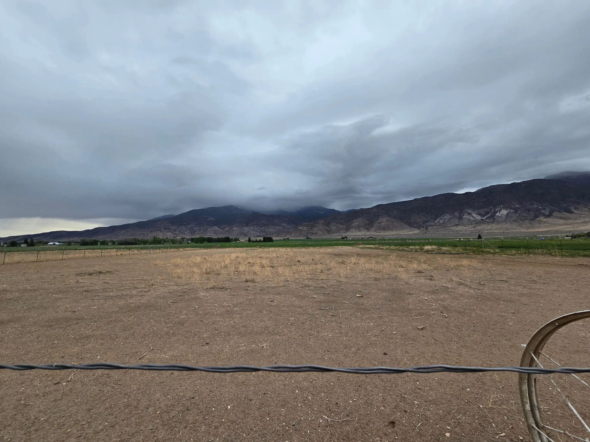 Expansive undeveloped land with distant mountain ranges and scattered greenery