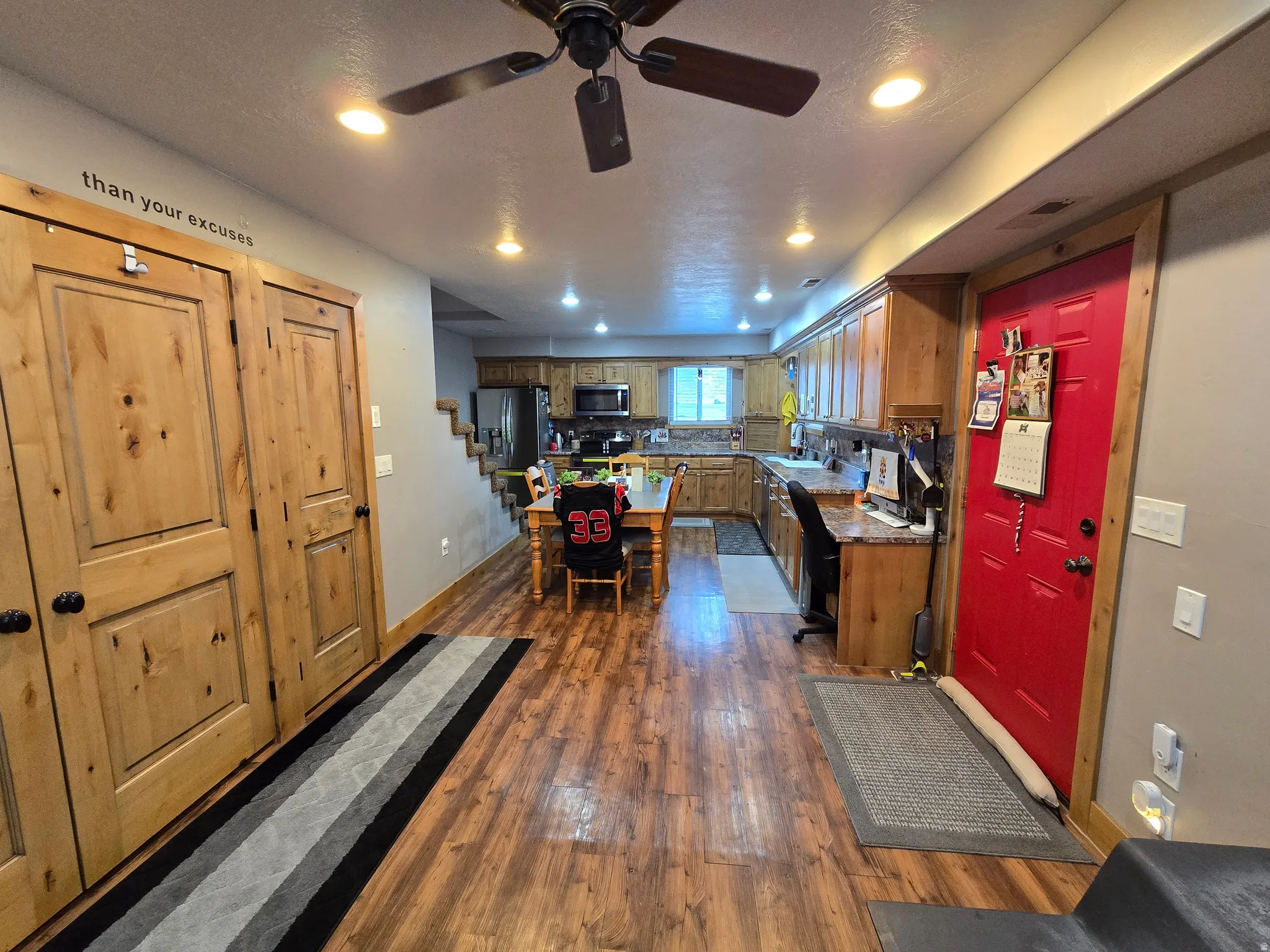 Open-concept kitchen and dining area featuring wood-finish flooring, recessed lighting, and a ceiling fan
