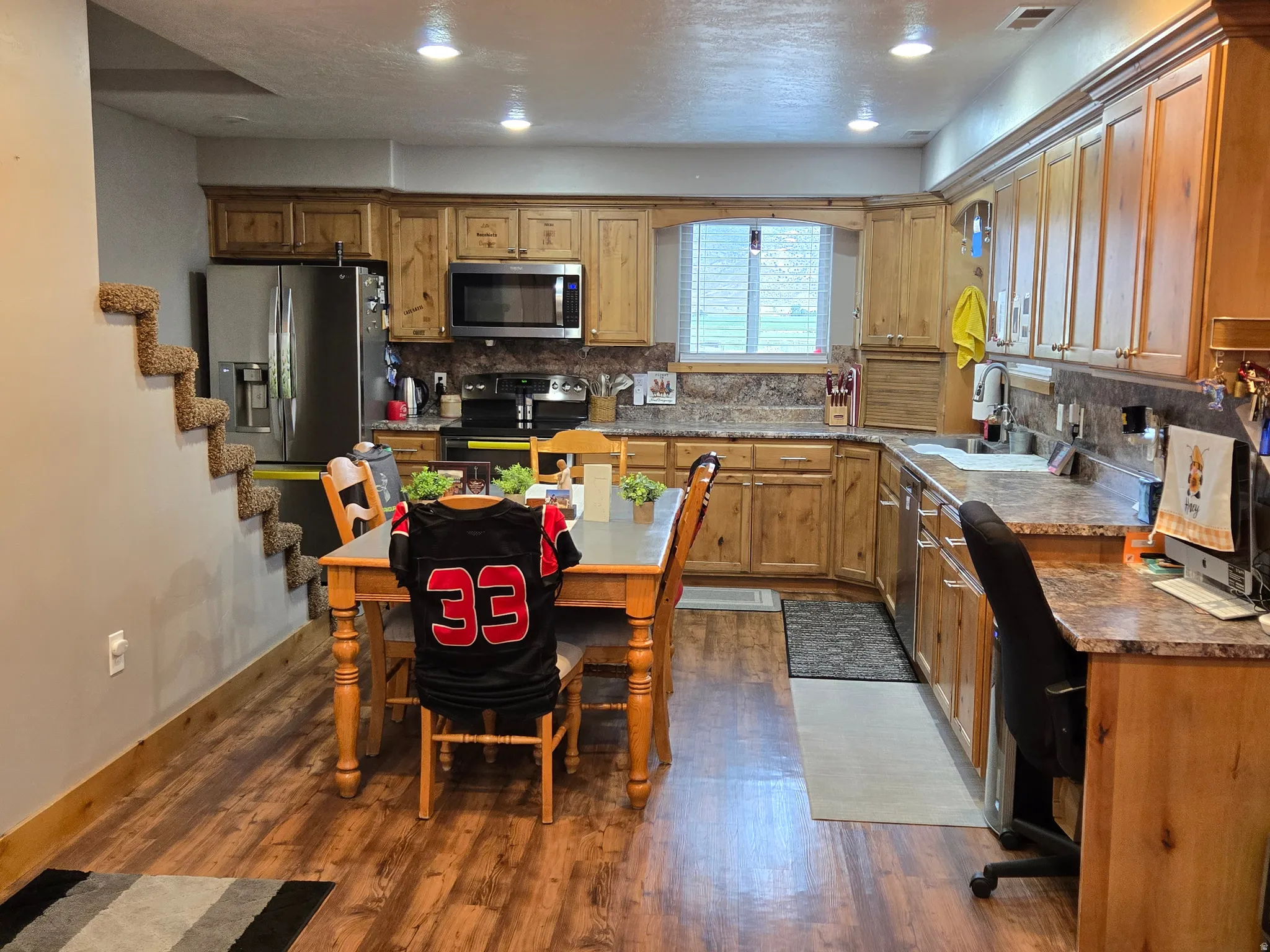 Kitchen featuring wood-finish flooring, recessed lighting, and wood cabinetry with crown molding