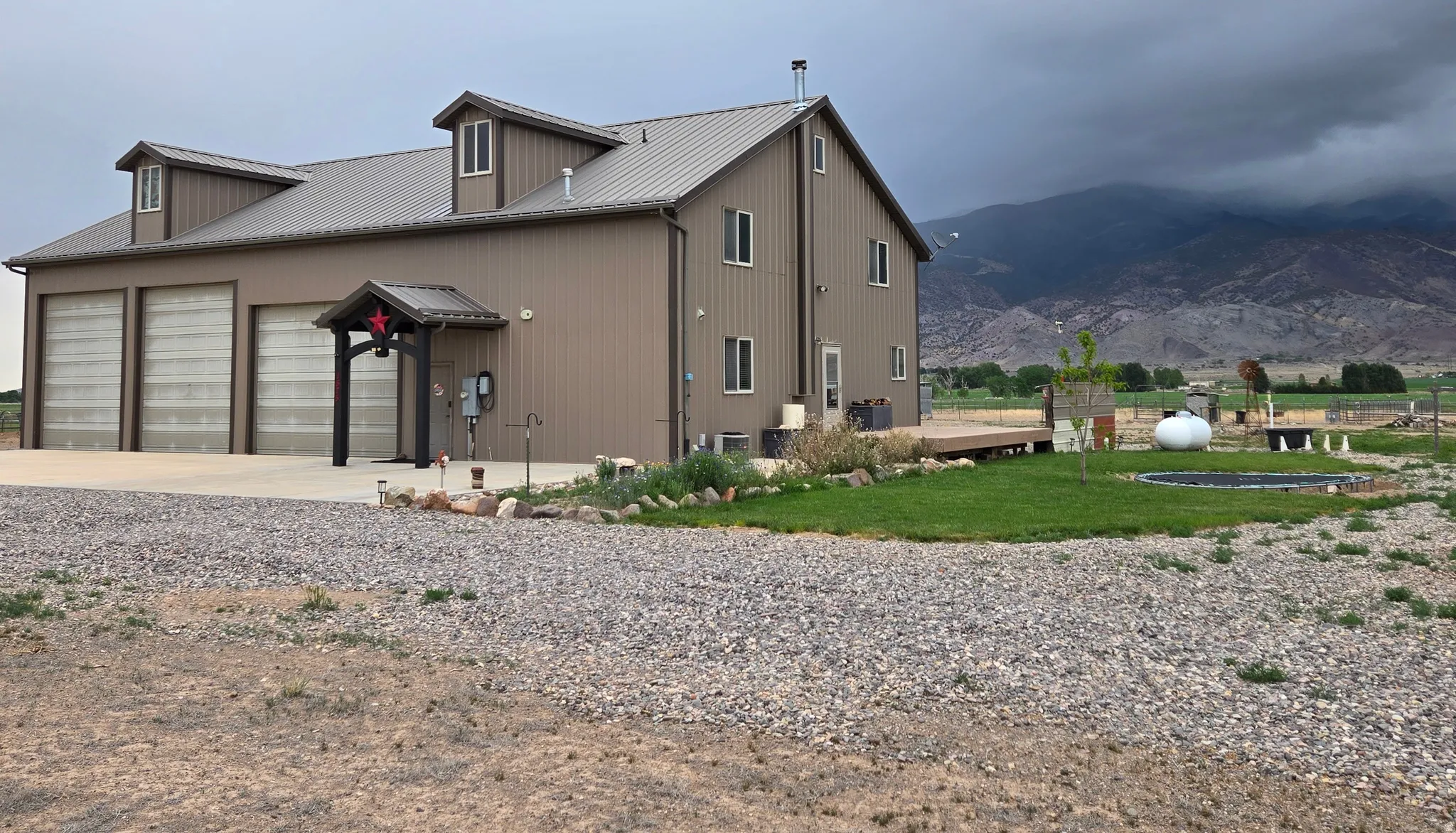 Metal-sided residence featuring a three-bay garage and a covered entry