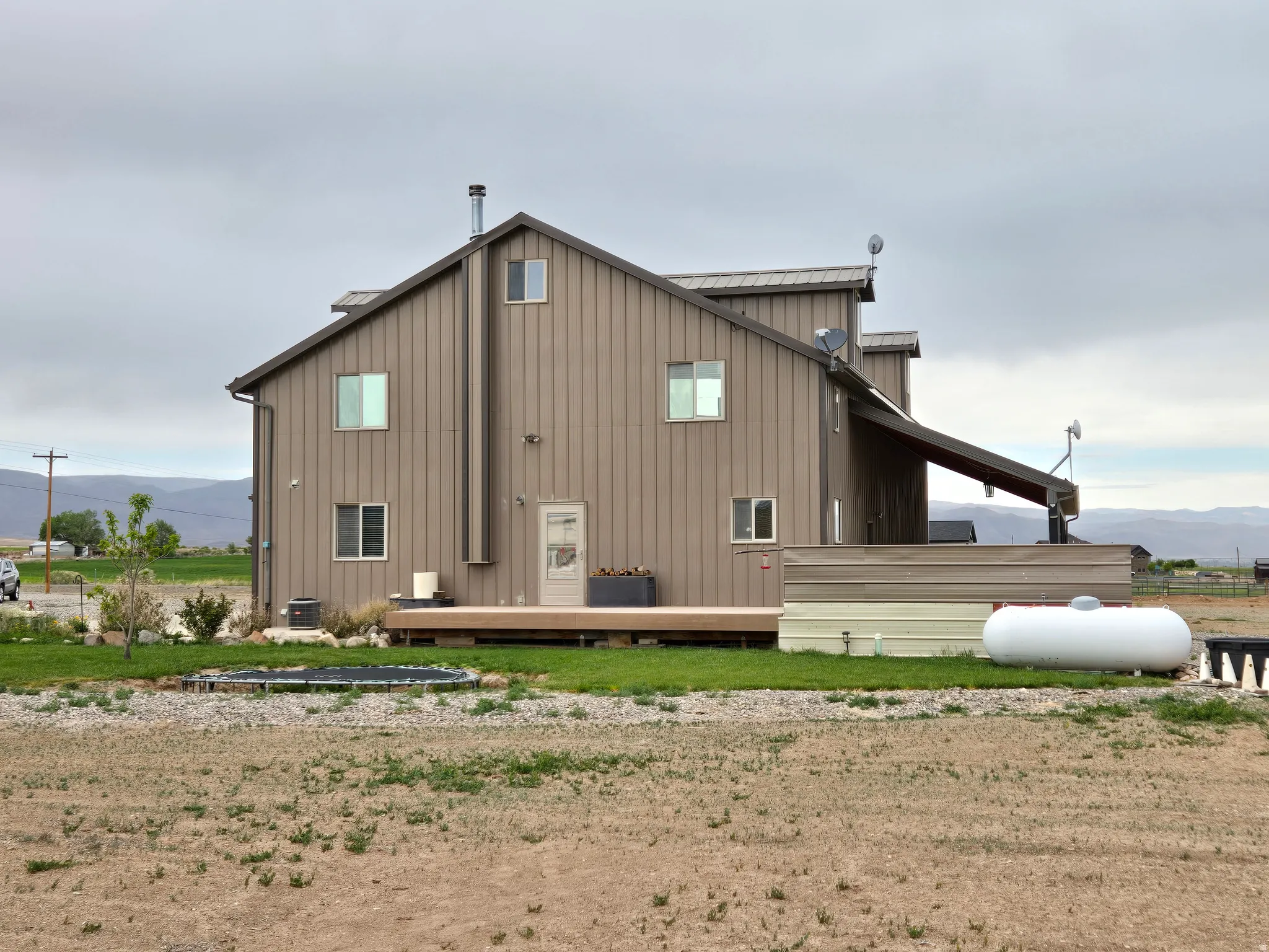 Brown vertical siding exterior with multiple windows and a pitched roof
