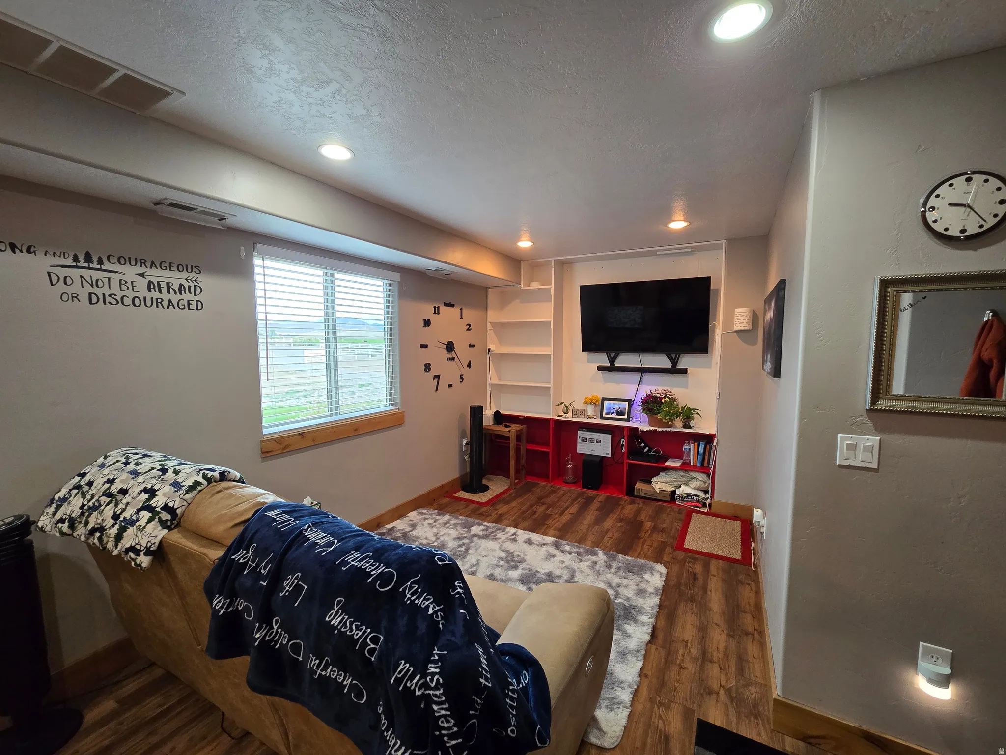 Living area featuring wood-finish flooring, recessed lighting, and a built-in media center with integrated shelving
