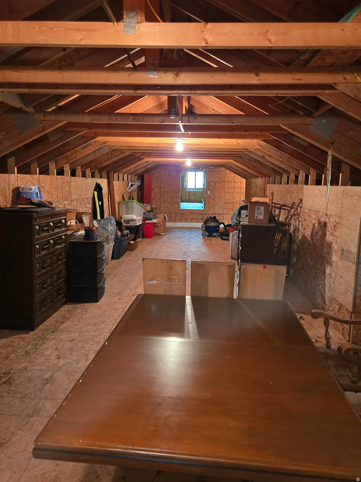 Expansive attic space featuring exposed wood beams and structural elements