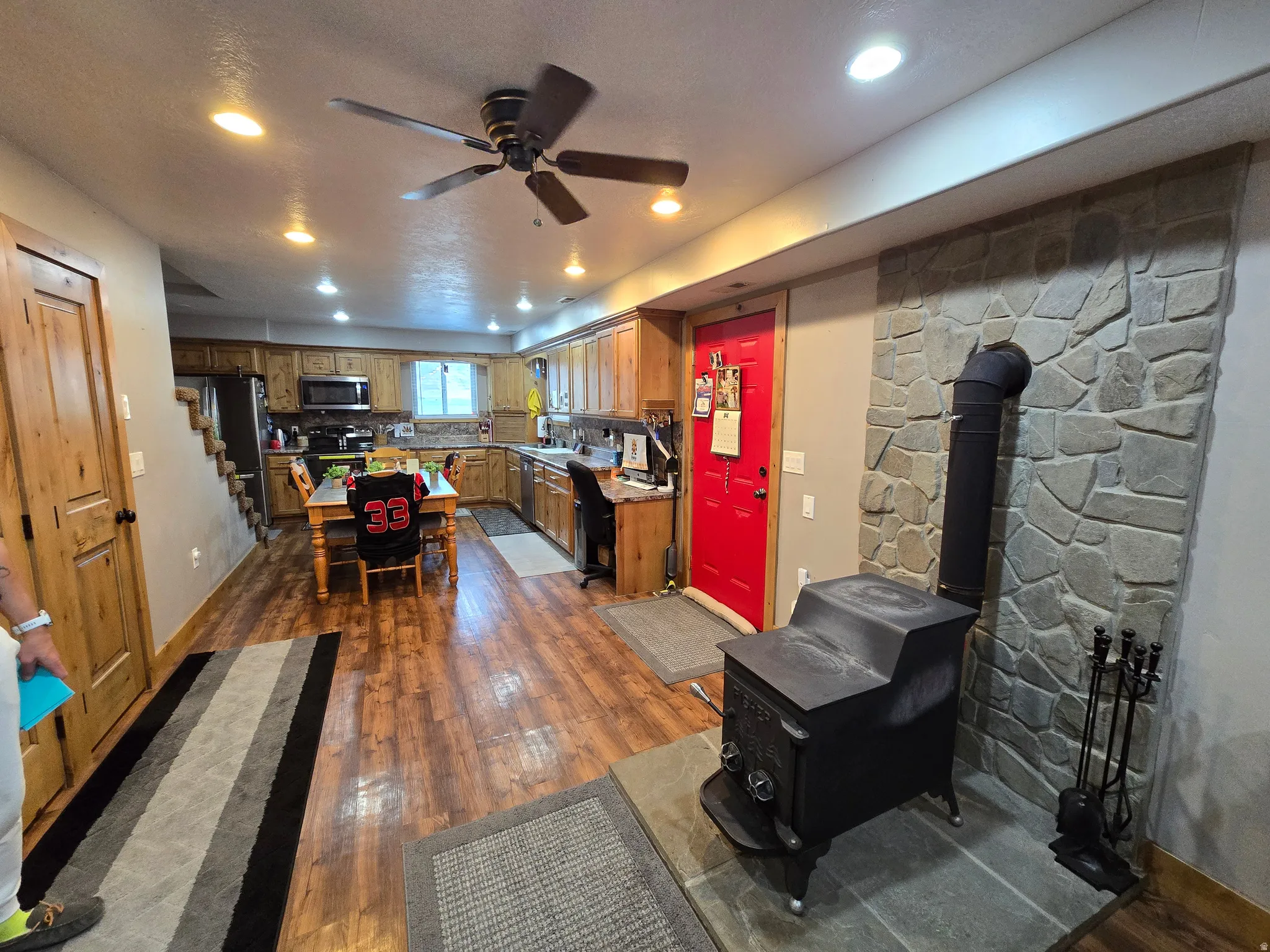 Spacious kitchen and living area featuring wood-finish flooring, recessed lighting, and a ceiling fan