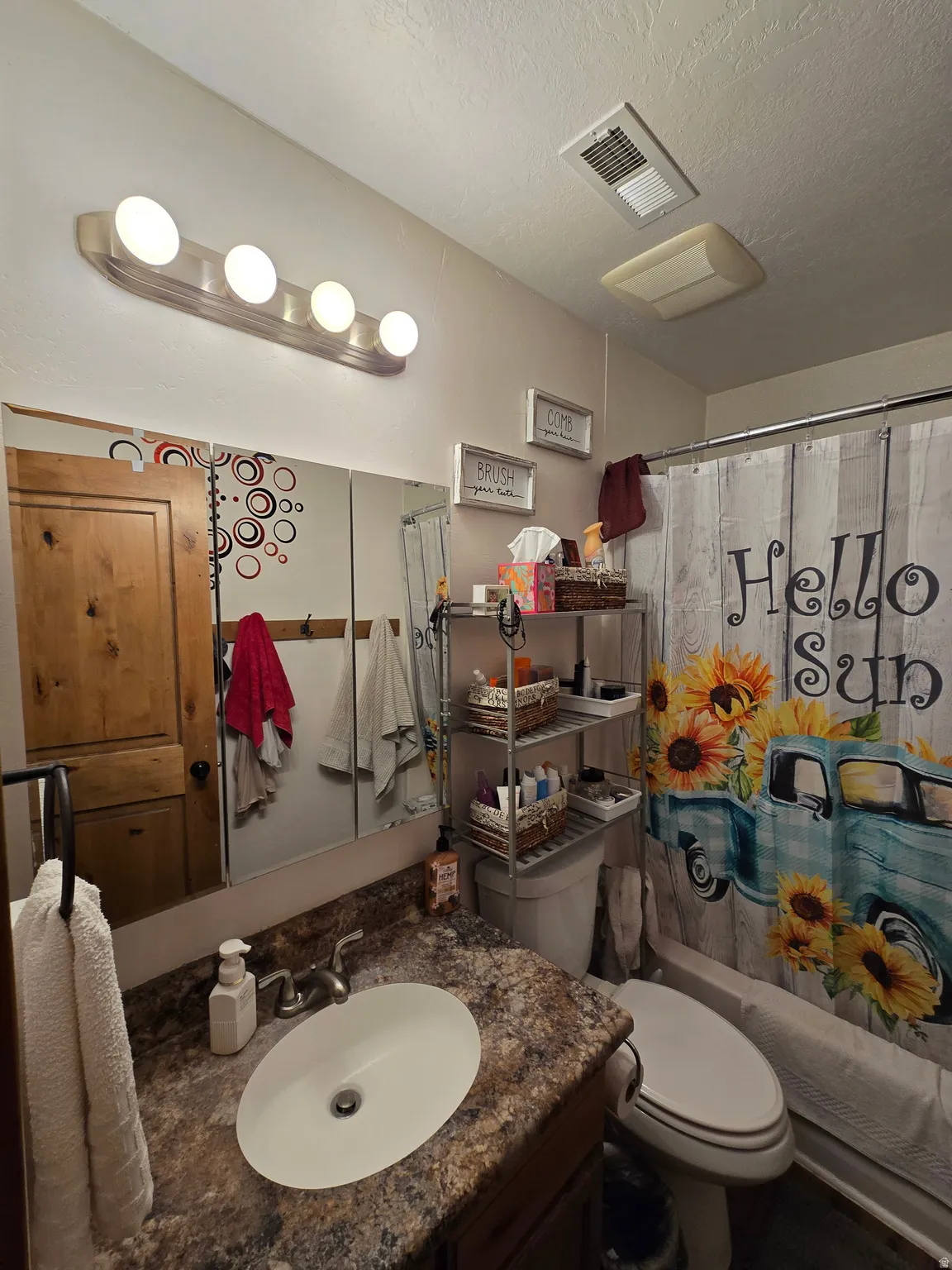 Bathroom featuring a vanity with an oval sink, a patterned countertop, and a built-in medicine cabinet