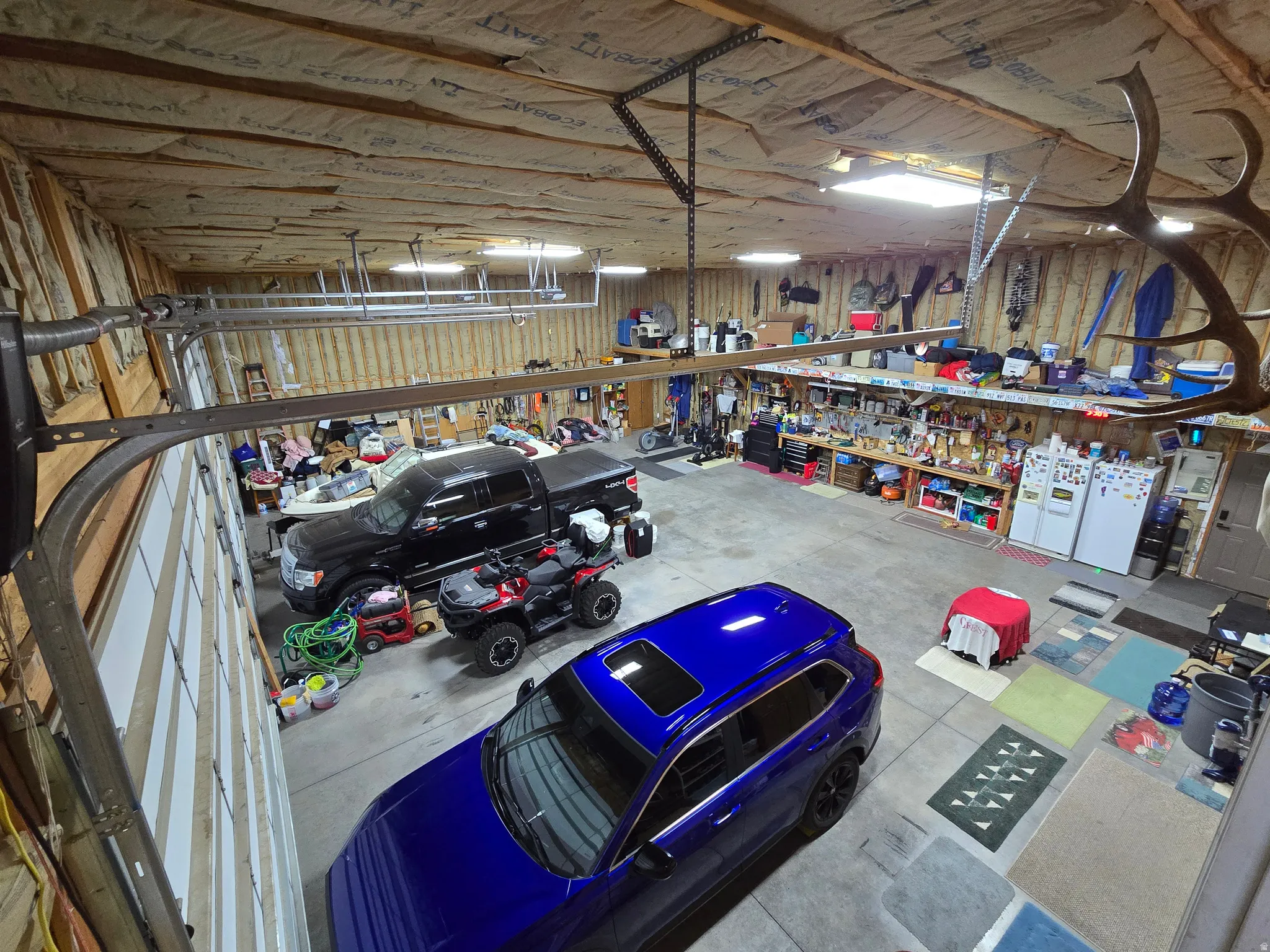 Spacious garage featuring concrete flooring and exposed wood-frame walls