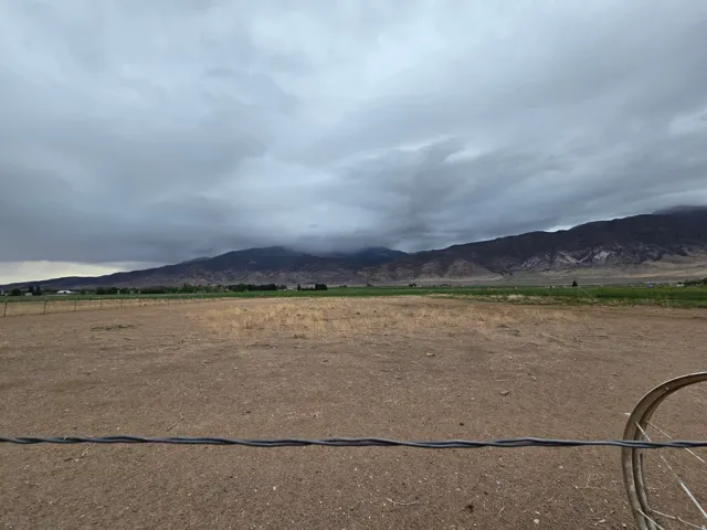 Expansive undeveloped land with distant mountain ranges and scattered greenery