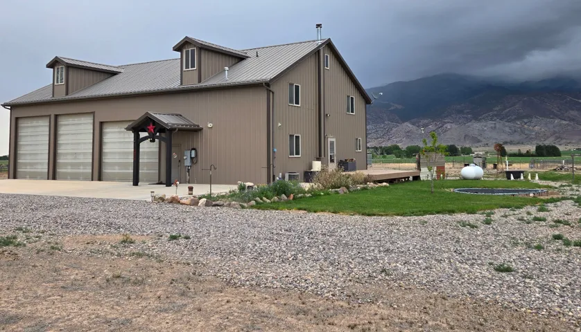 Metal-sided residence featuring a three-bay garage and a covered entry