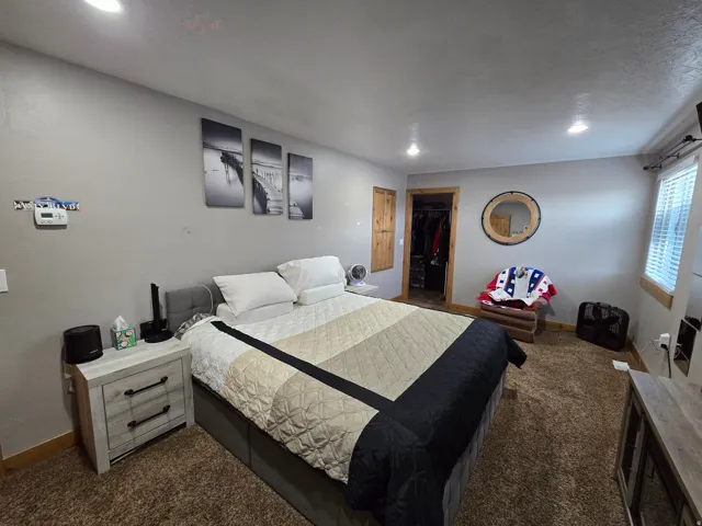 Carpeted room featuring recessed lighting and a window with blinds