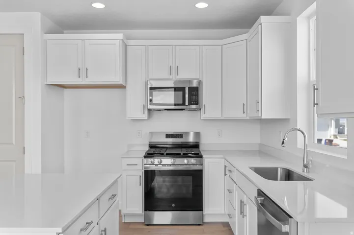 Modern kitchen featuring white cabinetry and light-colored countertops