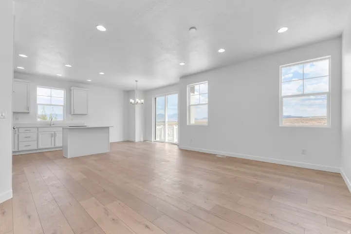 Open-concept living space featuring light wood-finish flooring, recessed lighting, and white walls