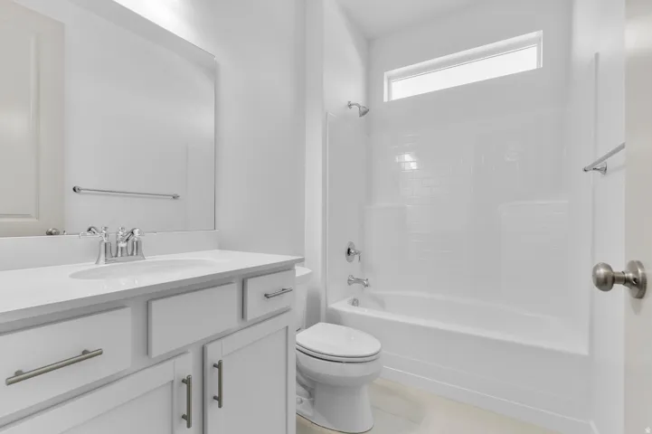 Bathroom featuring a white vanity with an integrated sink, polished chrome faucet, and cabinet storage